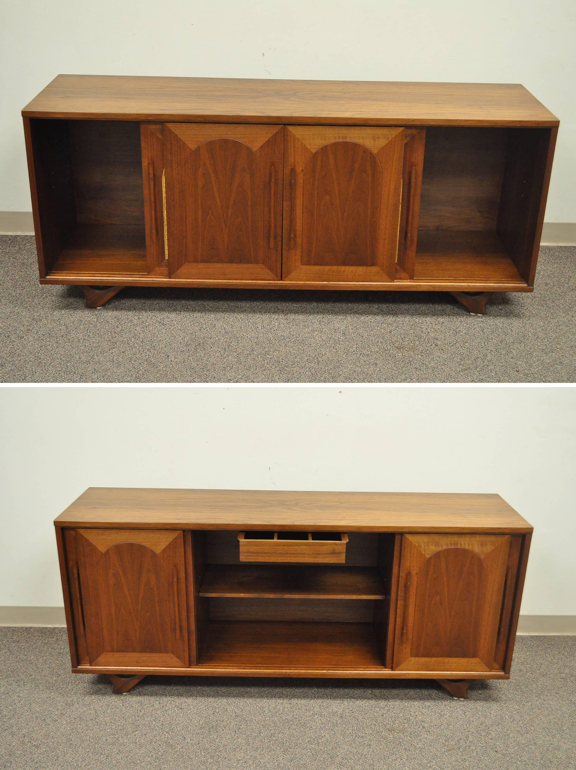Vintage Mid-Century Danish modern walnut and cane sliding door credenza cabinet. Item features beautiful wood grain, four sliding doors, two doors with arched cane panels, adjustable interior shelf, single drawer with unique wood joinery, sculpted