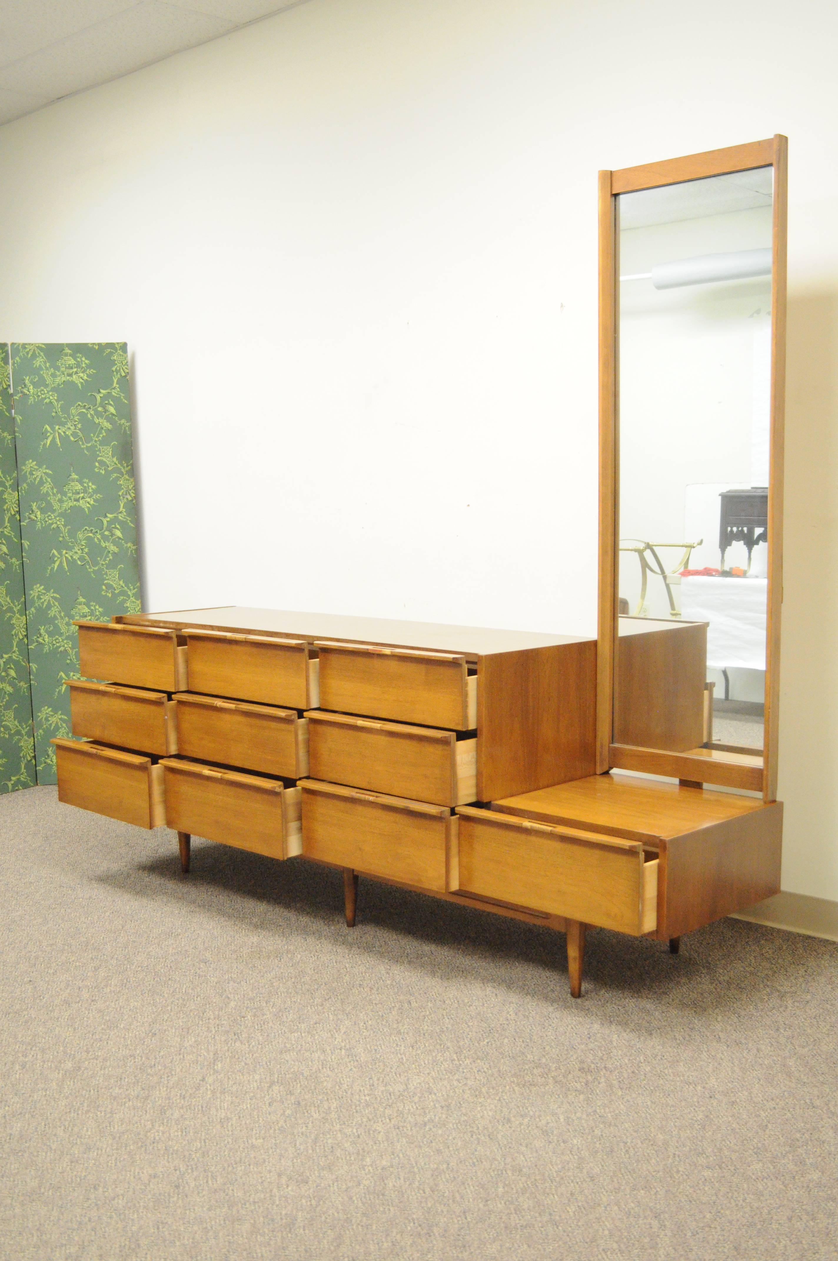 Vintage Mid-Century American Modern walnut dresser with mirror. Item features rattan wrapped handles, tall removable mirror with recessed edge, 10 dovetailed drawers, great form. Measurements: 30