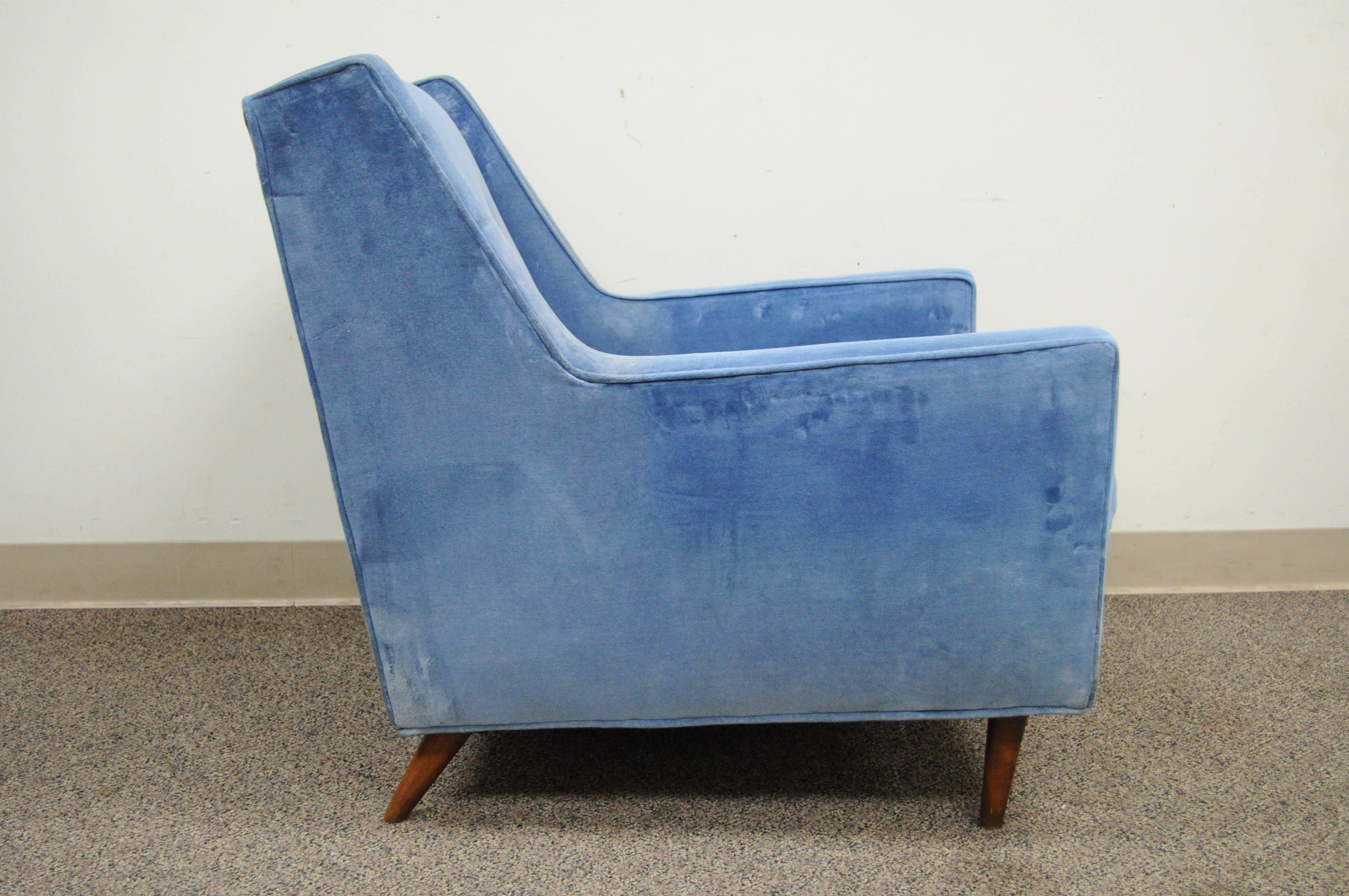 Quality vintage Mid-Century Modern club chair with sleek lines and sculptural form. Item features a solid wood frame with angled and tapered walnut legs, blue button tufted upholstery, and great American made quality. Chair is unmarked but the style