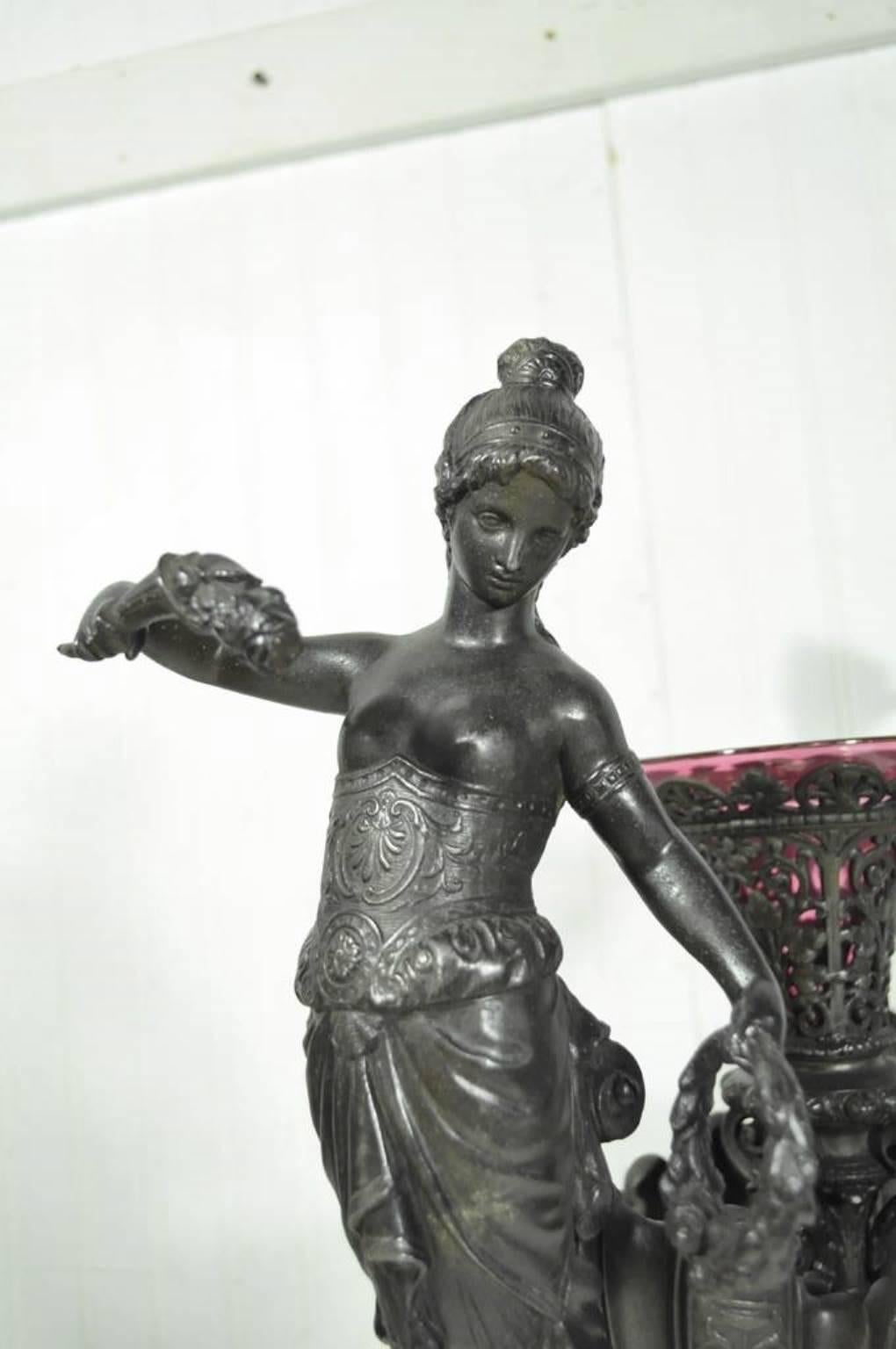 Antique Victorian spelter and marble figural mermaid centerpiece. Item features; black marble plinth, pinkish purple glass vase, two half-nude mermaid figures, finely cast metal details, substantial overall weight (approximate 32 lbs.)