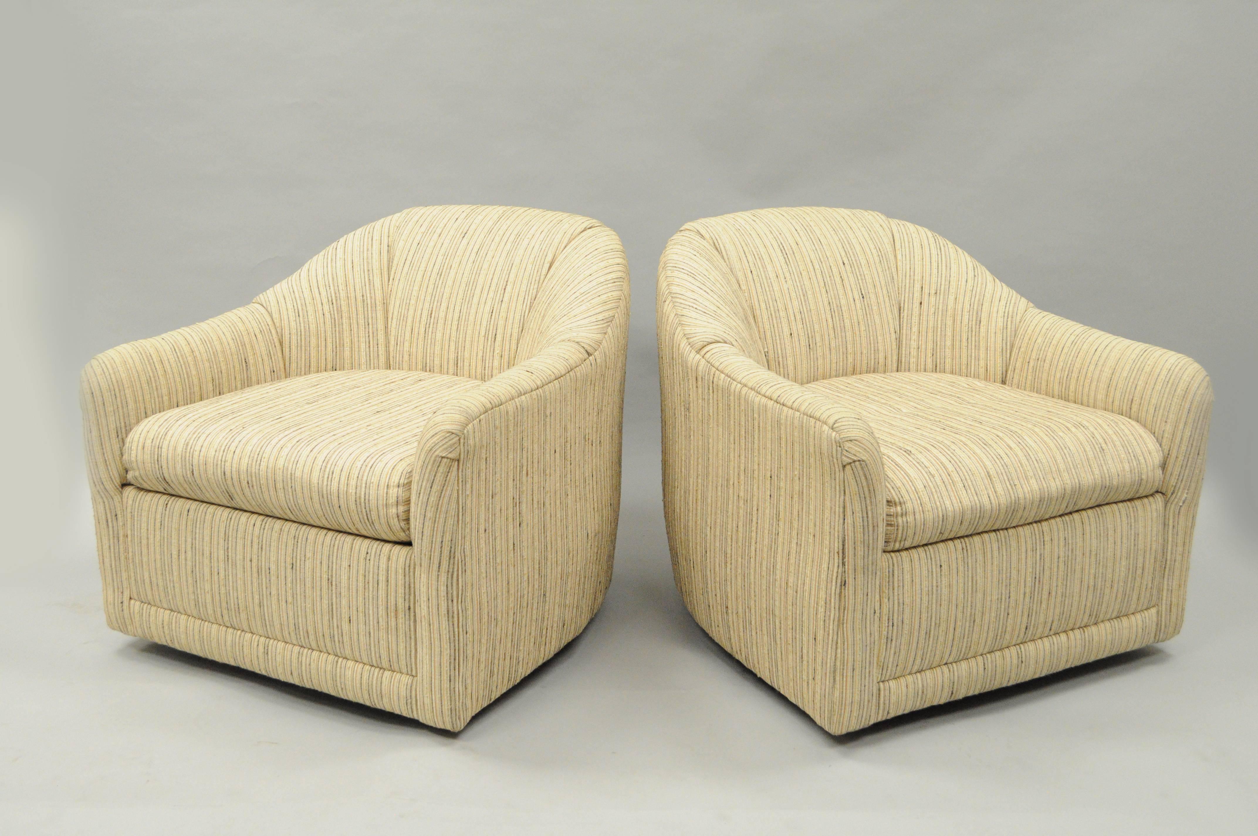 Original vintage pair of upholstered Mid-Century Modern barrel back revolving club lounge armchairs by Selig. Chairs feature clean Modernist lines, metal swivel star bases, fully upholstered frames in the original beige nubby weave fabric, and