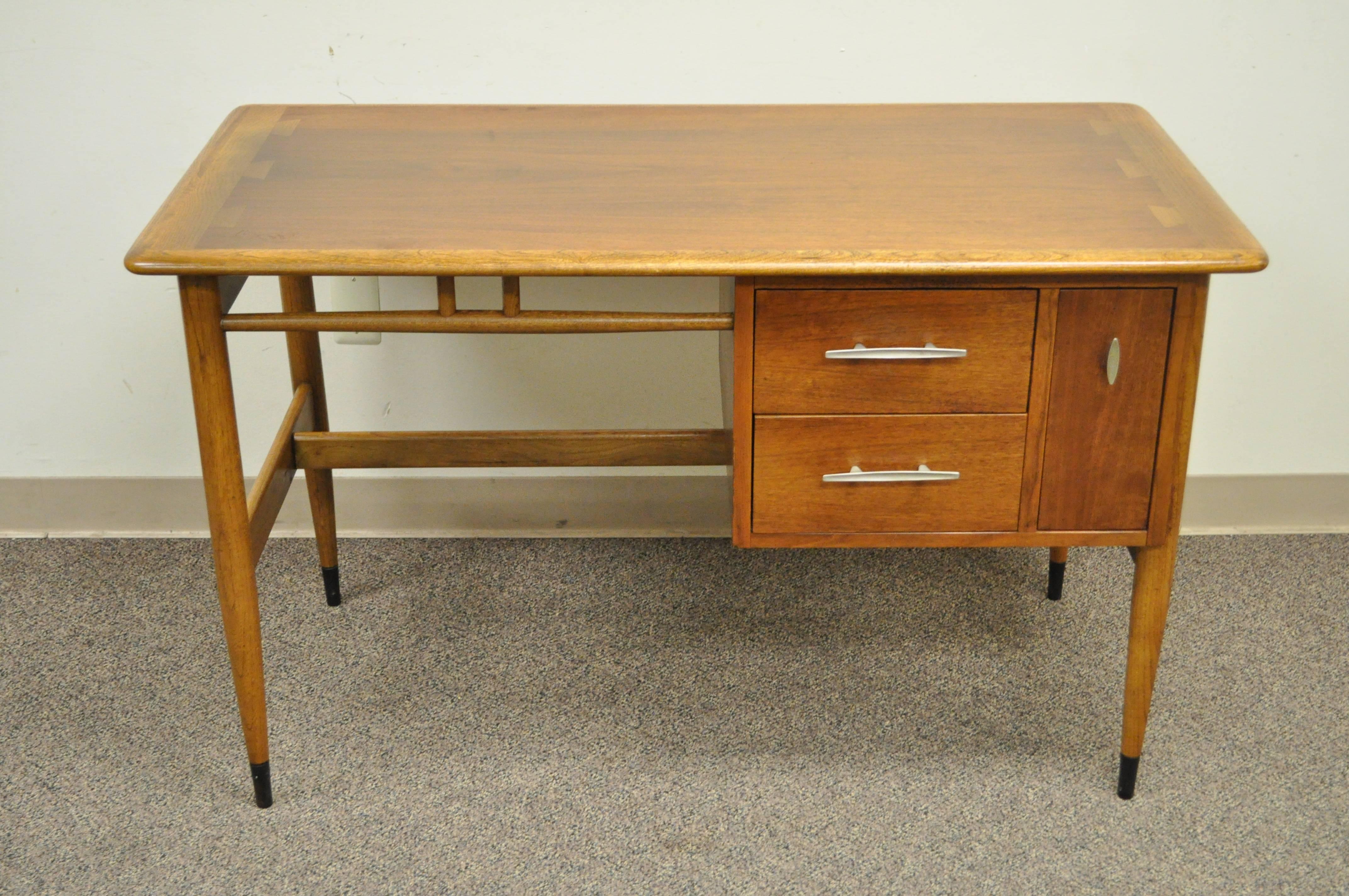 Vintage Mid-Century Modern walnut writing desk by Lane designed by Andre Bus in the Danish modern style. Item features solid wood construction, dovetailed top, three dovetail constructed drawers, finished back, sleek modernist lines, great American
