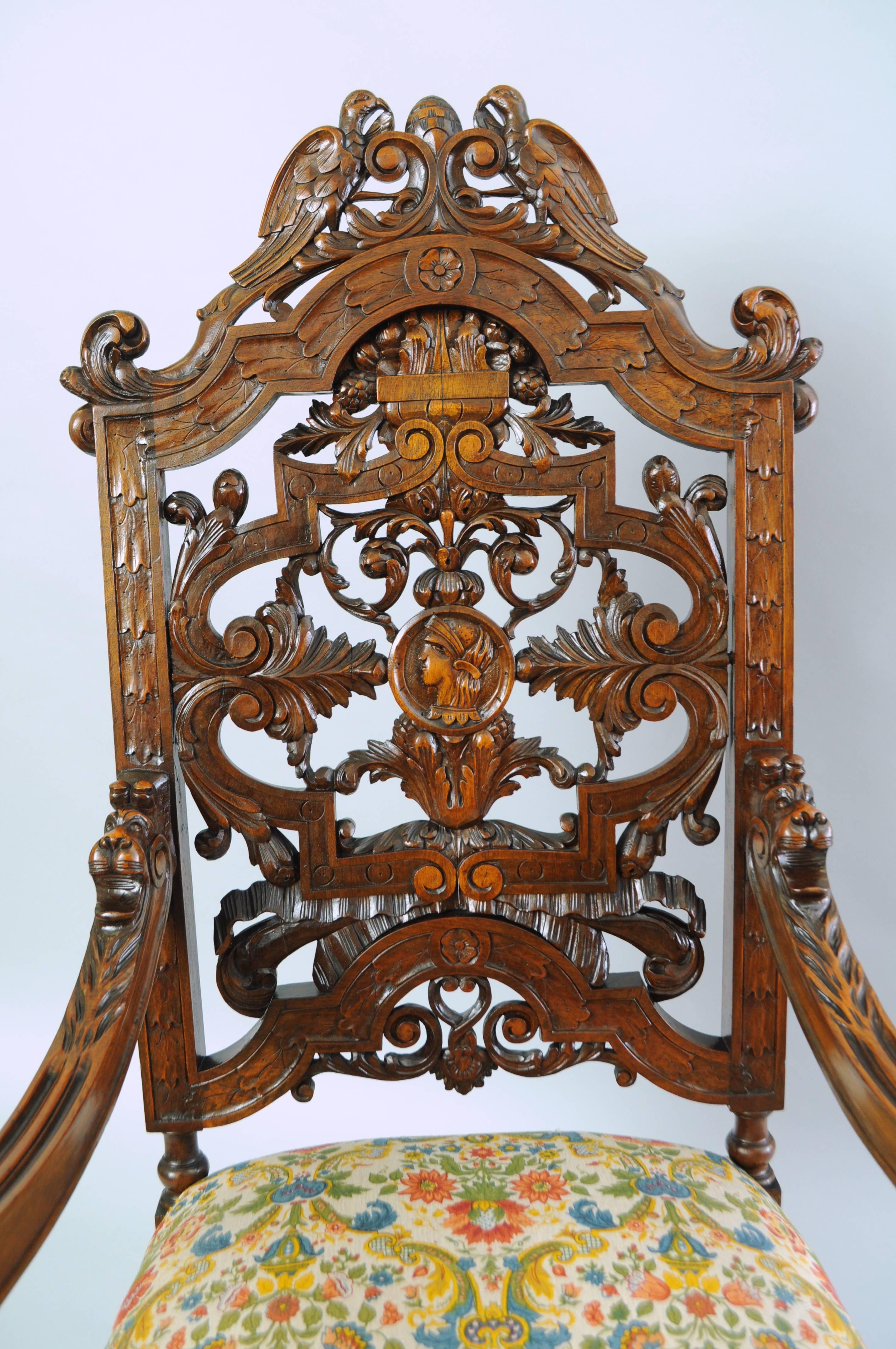Early 20th century figural carved walnut Italian Renaissance revival throne chair. Item features a high back, solid carved walnut frame with bird crest, pierce carved acanthus leaves throughout, lion heads on the armrests, central carved medallion