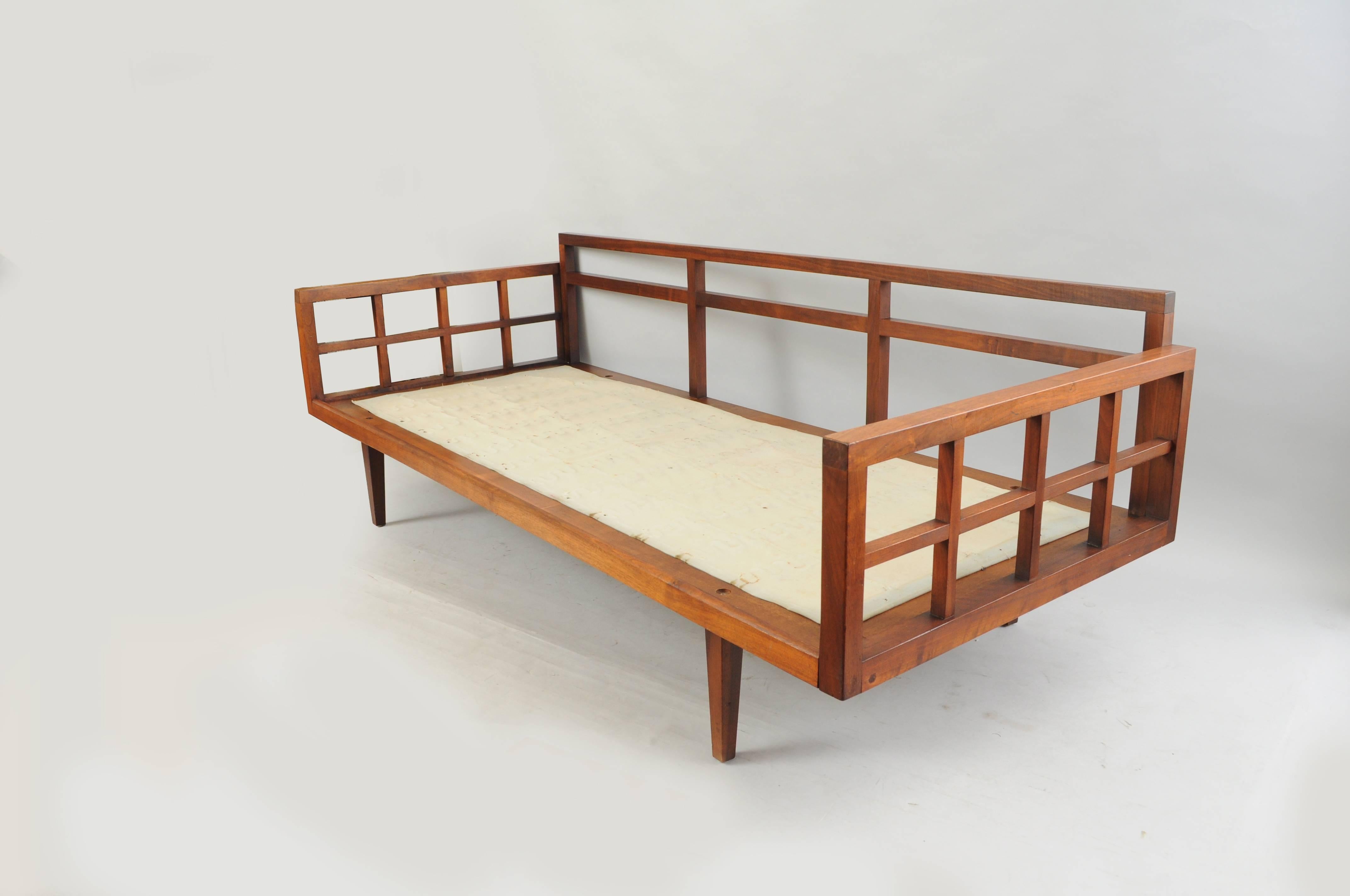 Vintage Mid-Century Modern teak and walnut wood sofa after Peter Hvidt in the Danish style. Item features a solid wood construction, open cut-out design, clean Modernist lines, square frame, tapered legs, beautiful wood grain, and great overall