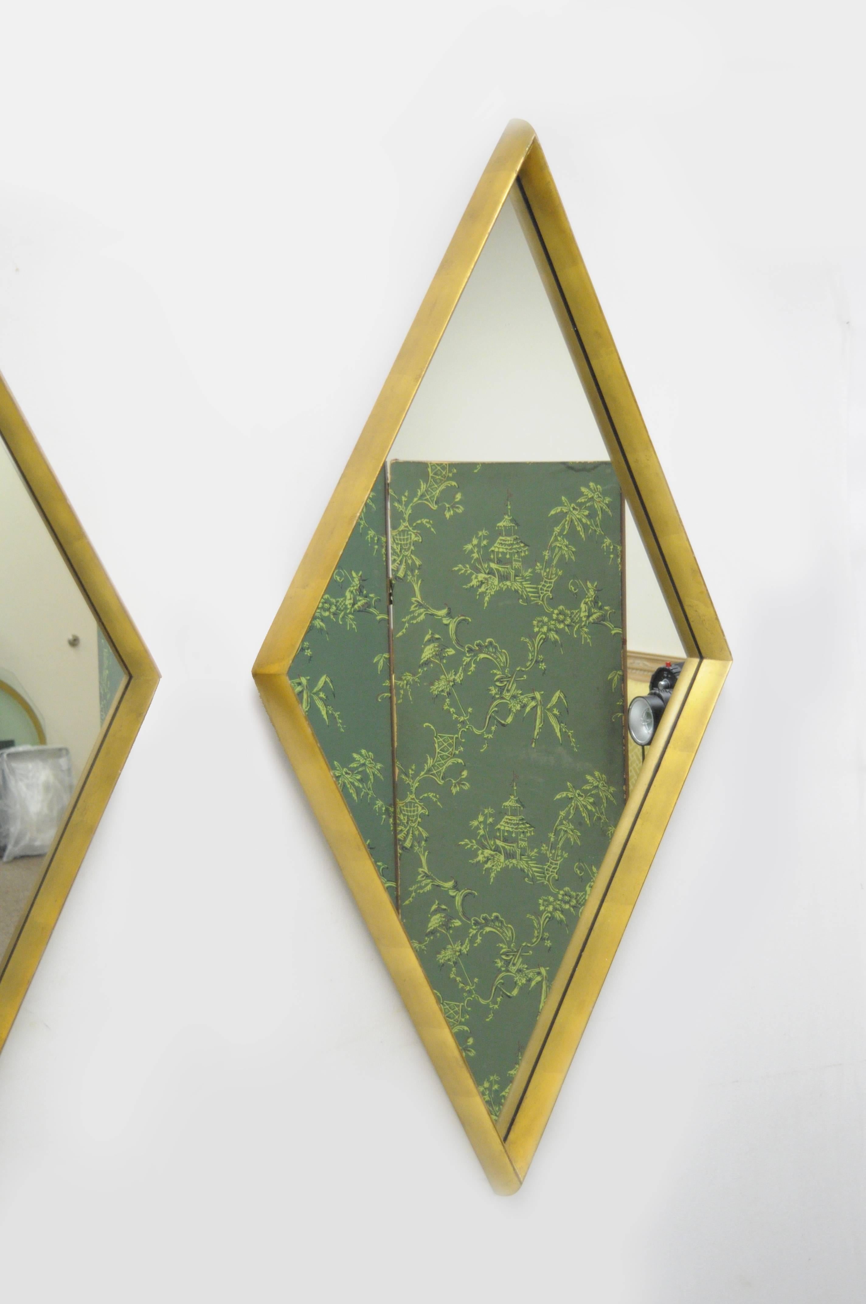 Attrayante paire de miroirs muraux vintage Hollywood Regency en forme de diamant attribués à Labarge avec des cadres profonds en bois façonné et une finition originale à la feuille d'or antique.