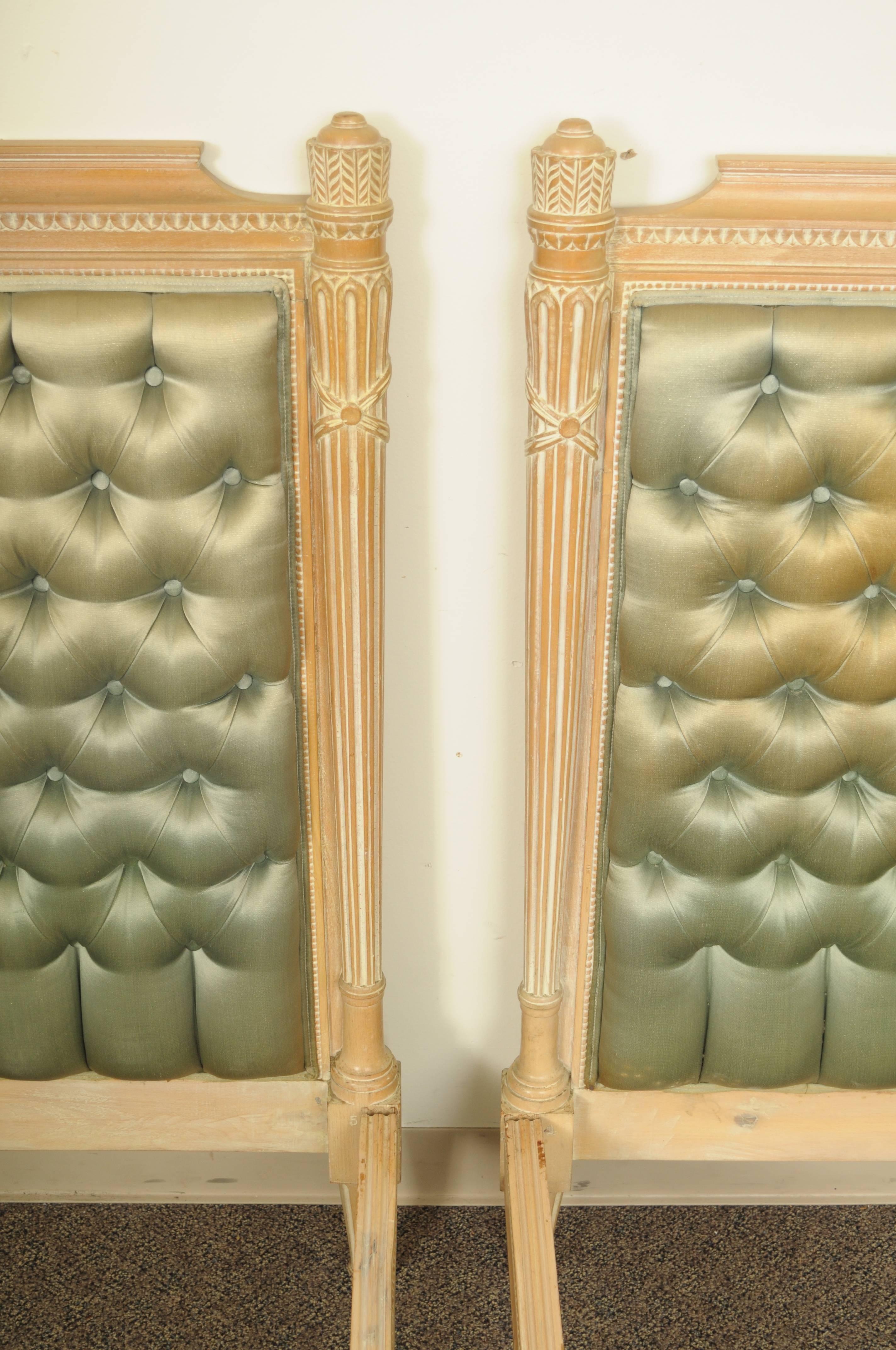 High quality pair of vintage carved and upholstered neoclassical style single / twin beds, made in Italy. Beds feature finely carved solid wood headboards and footboards with white washed distress painted finish. Frames feature unique wheat sheaf