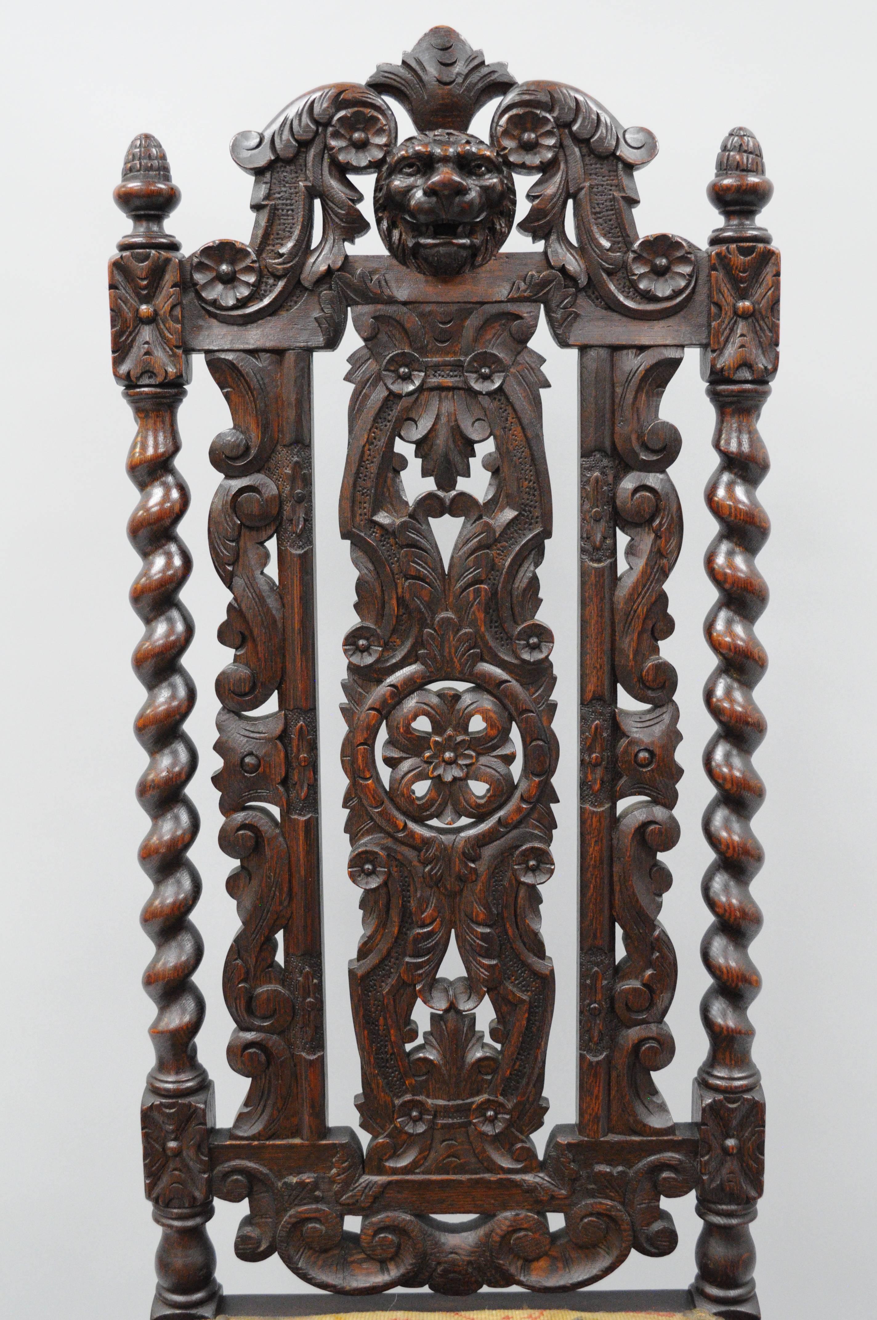 Pair of antique Renaissance Revival figural lion carved oak barley twist high back throne chairs. Item features a finely carved solid oakwood frame, including a carved lion head crest, acorn finials, daisy and acanthus leaf carvings, pierce carved