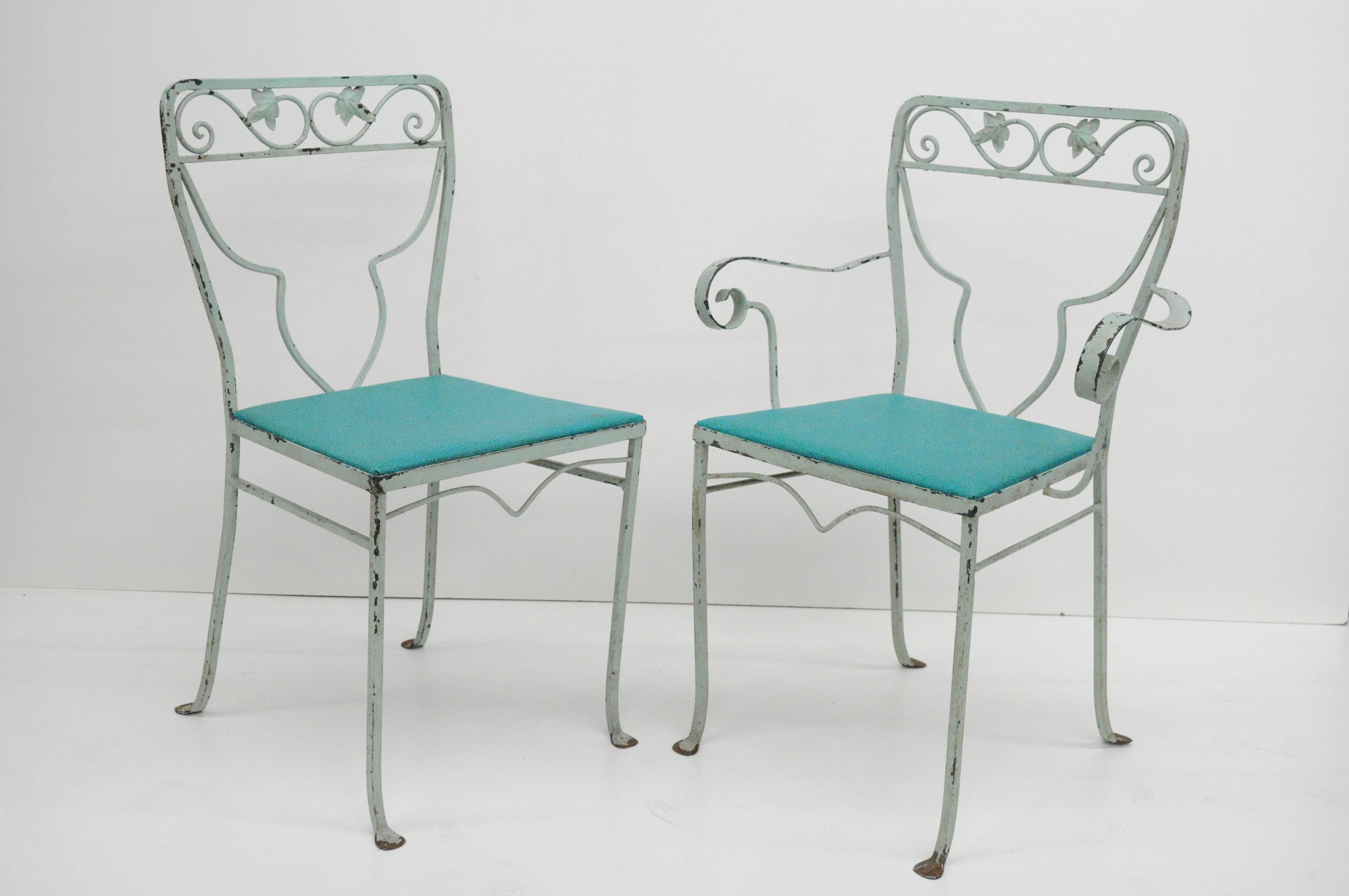 Vintage seven-piece Salterini blue painted wrought iron Mid-Century patio dining set. Set consists of four sidechairs, two armchairs, one wrought iron rectangular dining table with wavy ripple glass top, and scrolling floral art nouveau design. The