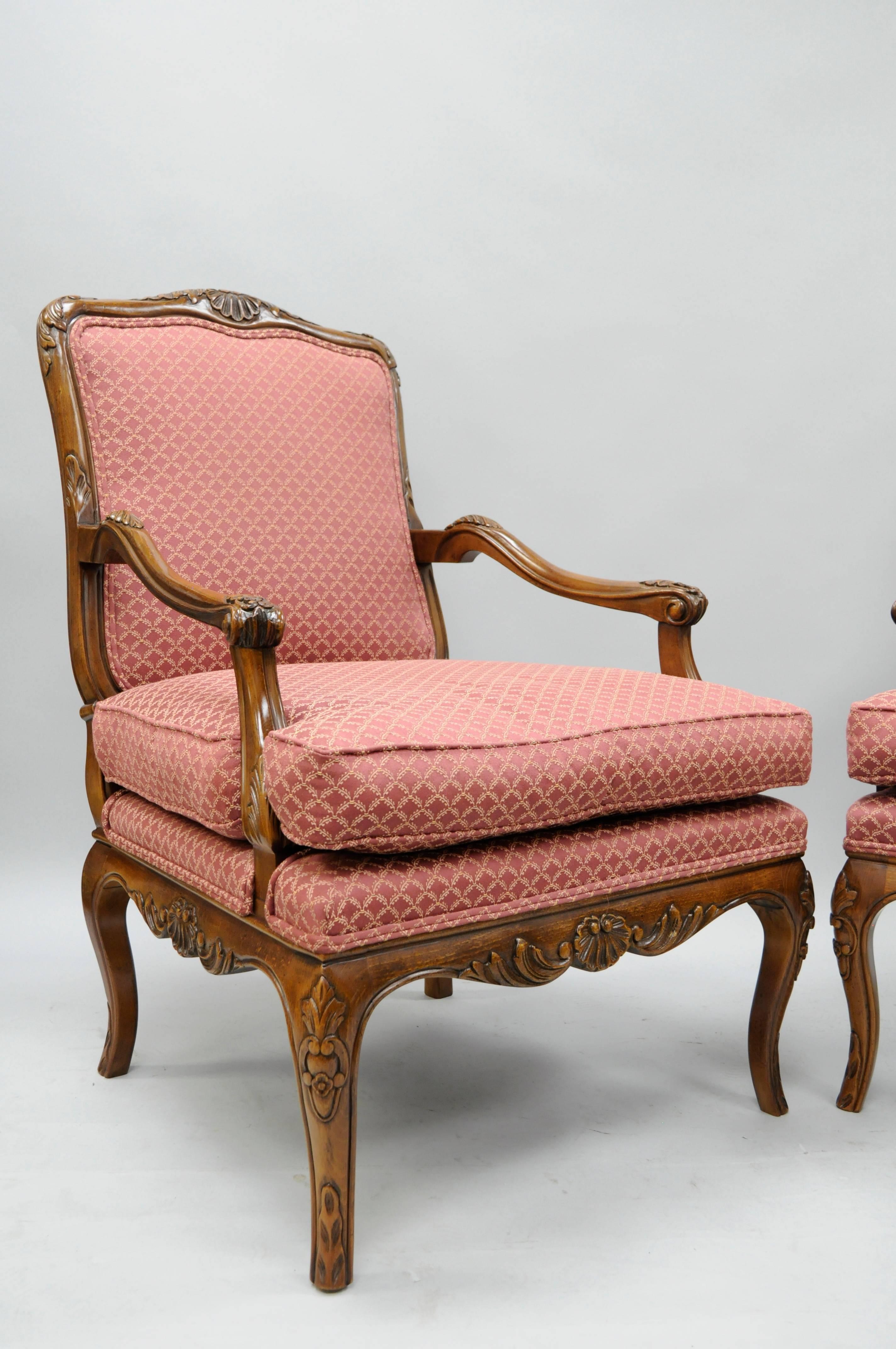 Pair of 20th century, high quality, country French / Louis XV style shell carved living room lounge chairs by Century Chair Company. The pair features solid carved wood frames, deep comfortable seats, finely carved skirts with shell and floral