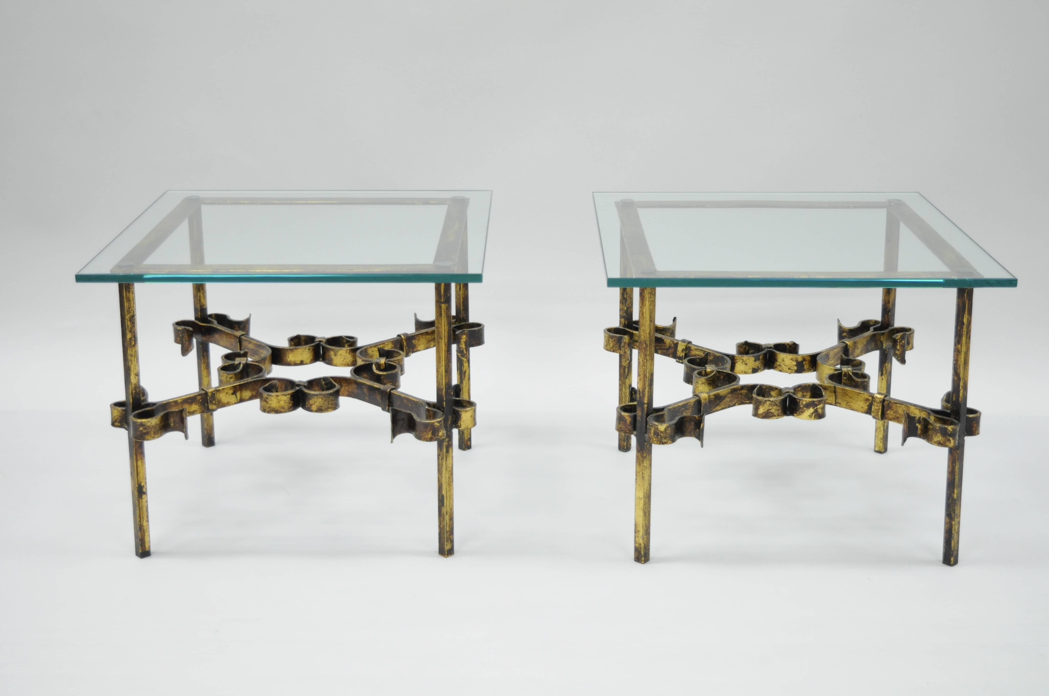 Pair of vintage Brutalist / Hollywood Regency scrolling gilded iron square glass top end tables. This item features .5