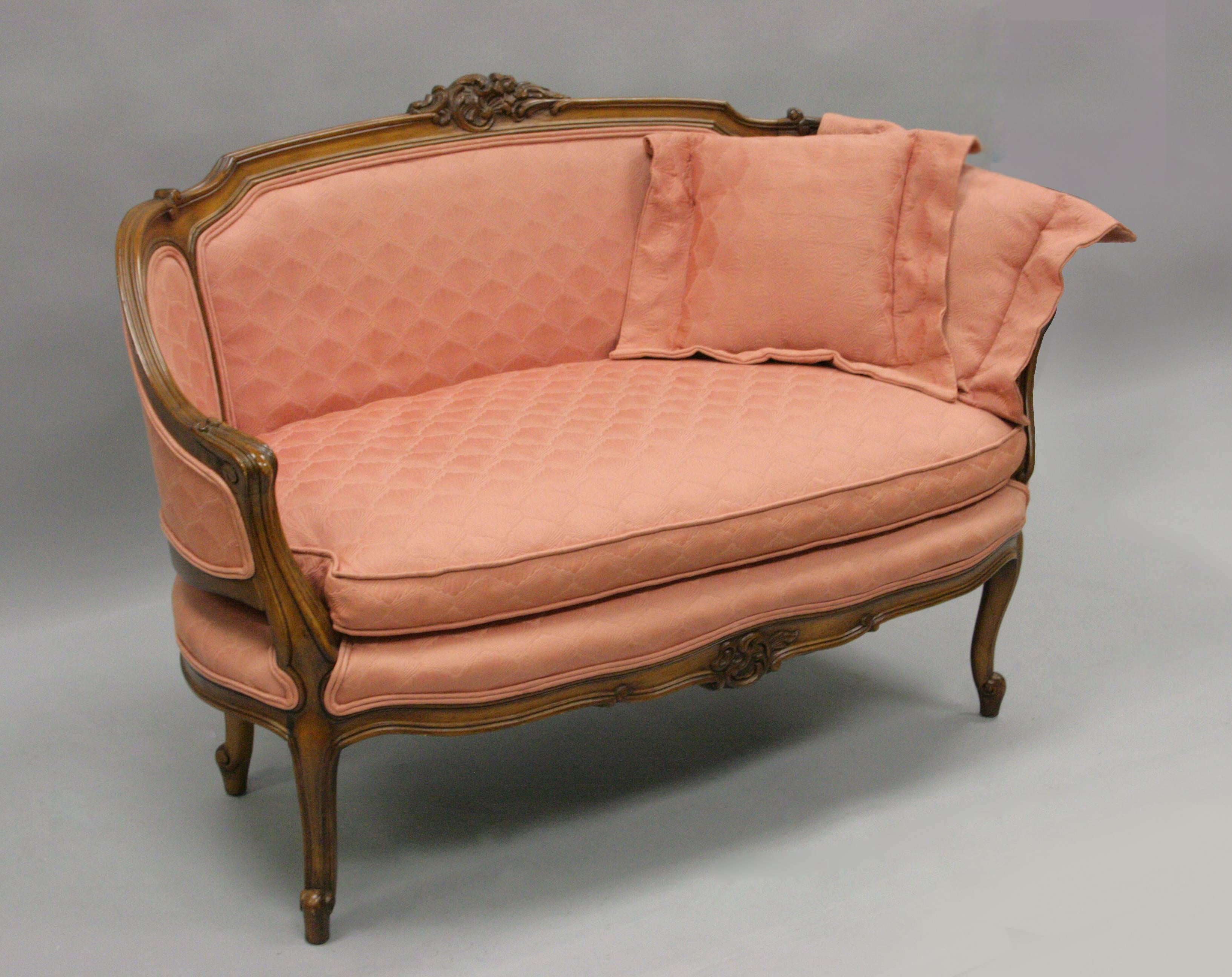 Beautiful vintage French Louis XV / country style carved walnut and pink upholstered settee. Item features four shapely cabriole legs, solid wood frame, carved pediment at the upper and lower rail, curved and carved arms, and great overall ovoid