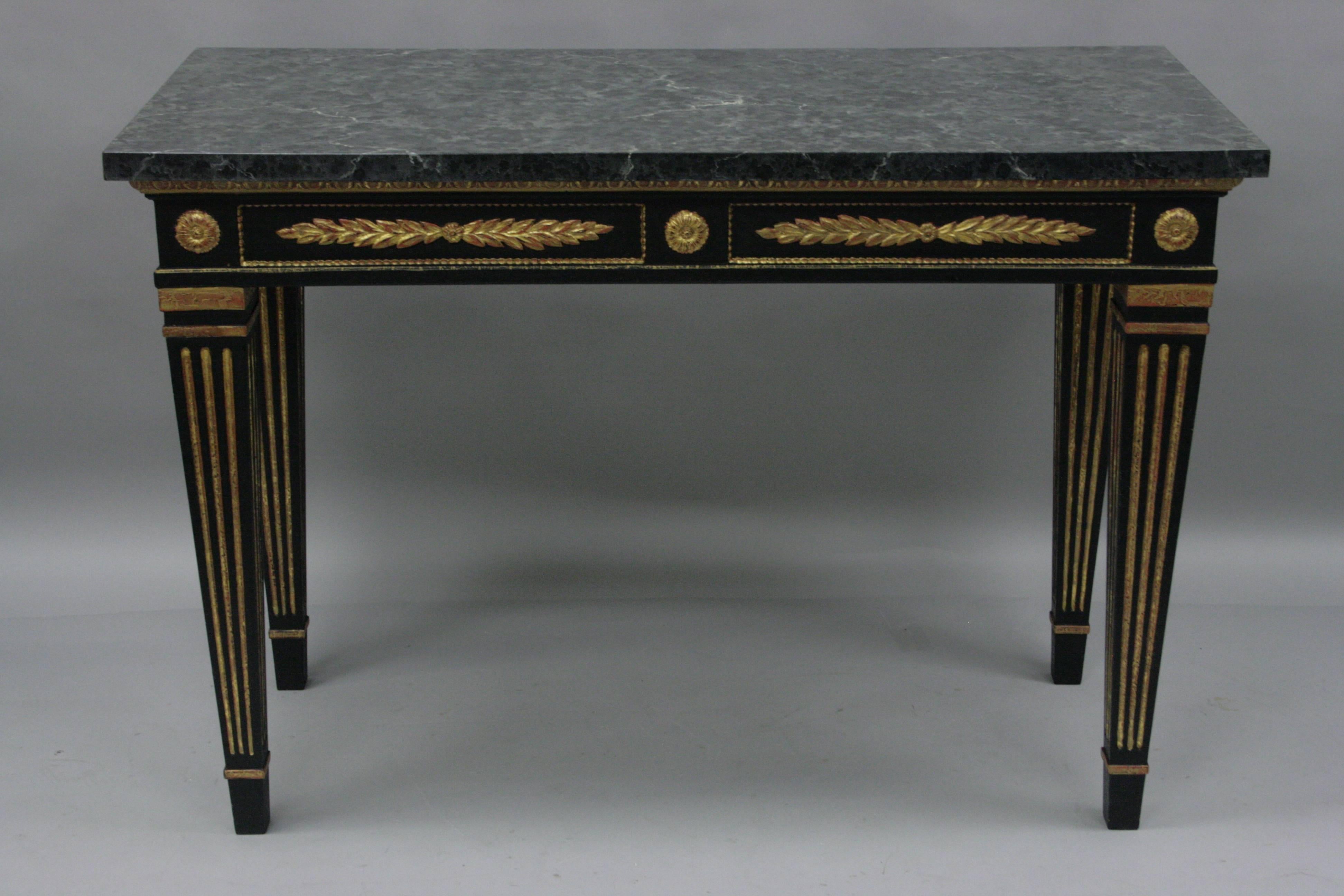 Beautiful late 20th century carved wood Louis XVI French style console table. This contemporary decorator table features a faux marble painted top, carved wood base finished in black and gold, tapered legs, elegant Directoire / Louis XVI form. Very