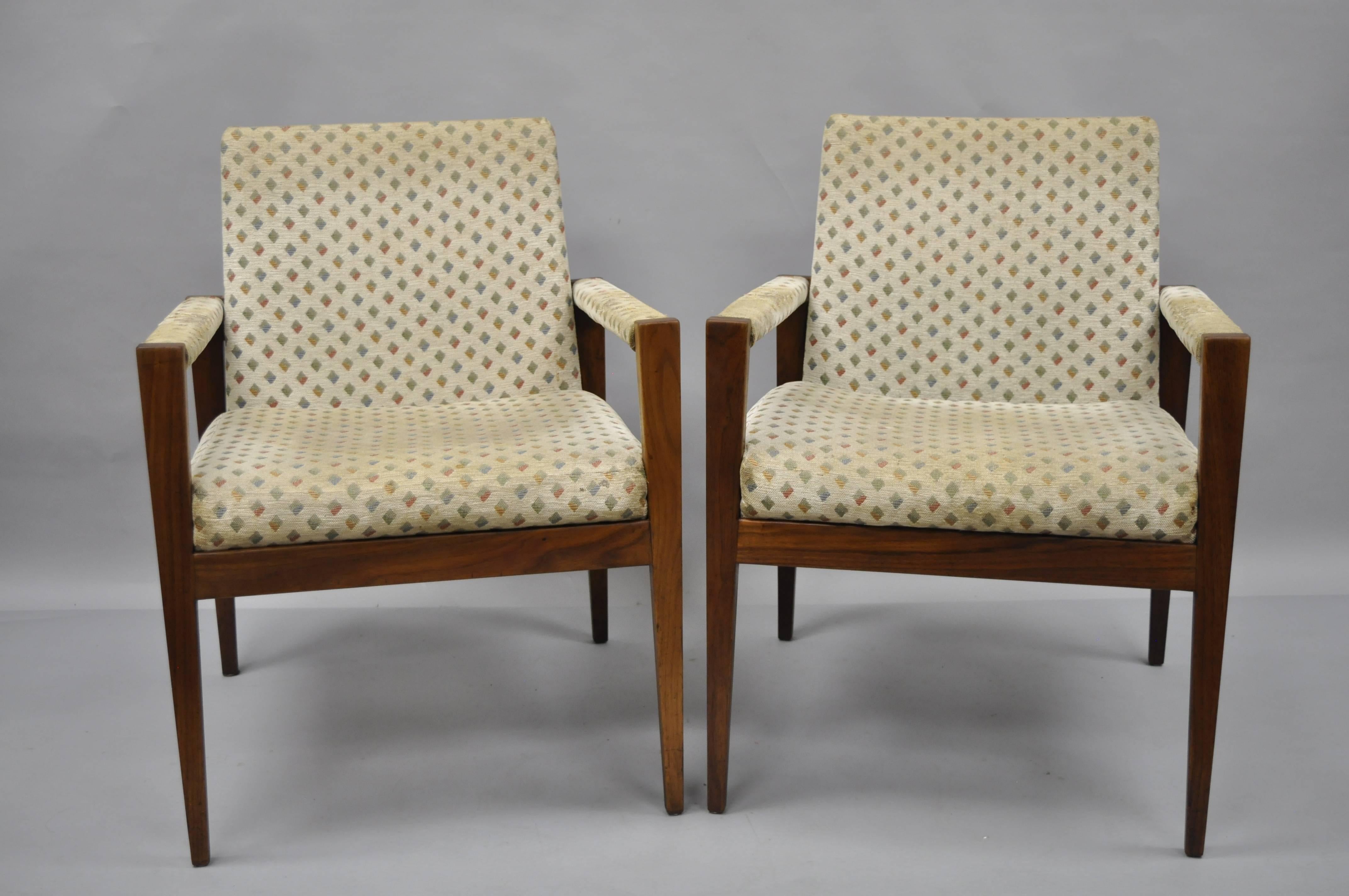 Pair of vintage Jens Risom walnut armchairs manufactured by Gaylord Brothers. These Mid-Century Modern chairs feature solid wood frames, beautiful wood grain, sleek tapered legs, upholstered armrests, and clean Modernist lines. Gaylord Brothers