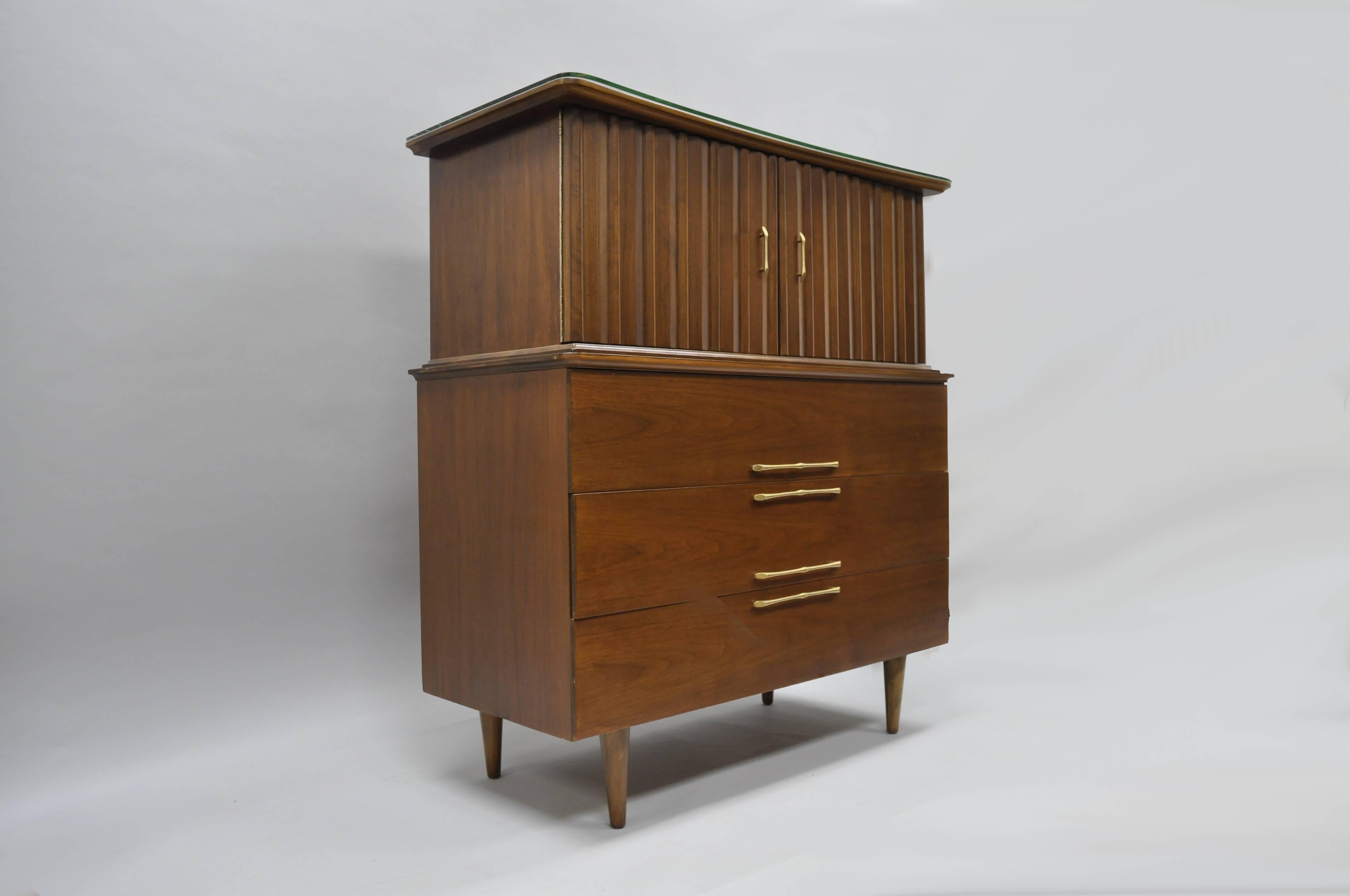 Superb vintage midcentury American modern walnut chest. Original owners had dresser professionally refinished inside and out with custom angled glass top added. Item features two sculptural walnut doors, seven dovetailed drawers, shaped top and