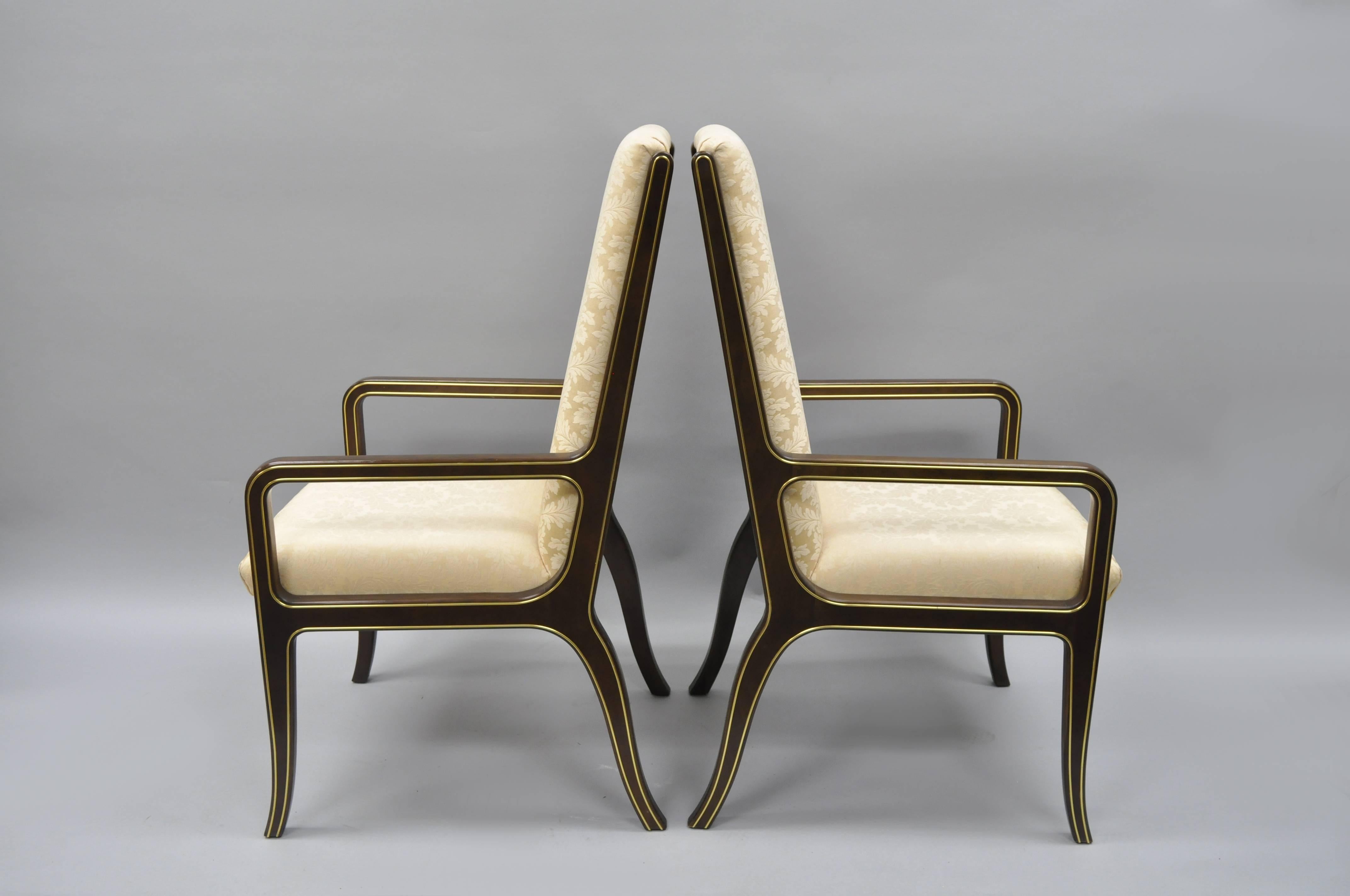 High quality pair of Mastercraft for Baker Furniture Co. Mid-Century Modernist armchairs. Chair feature sculptural solid wood frames (believed to be solid mahogany) with brass inlaid trim throughout and upholstered seats and backs. This clean lined