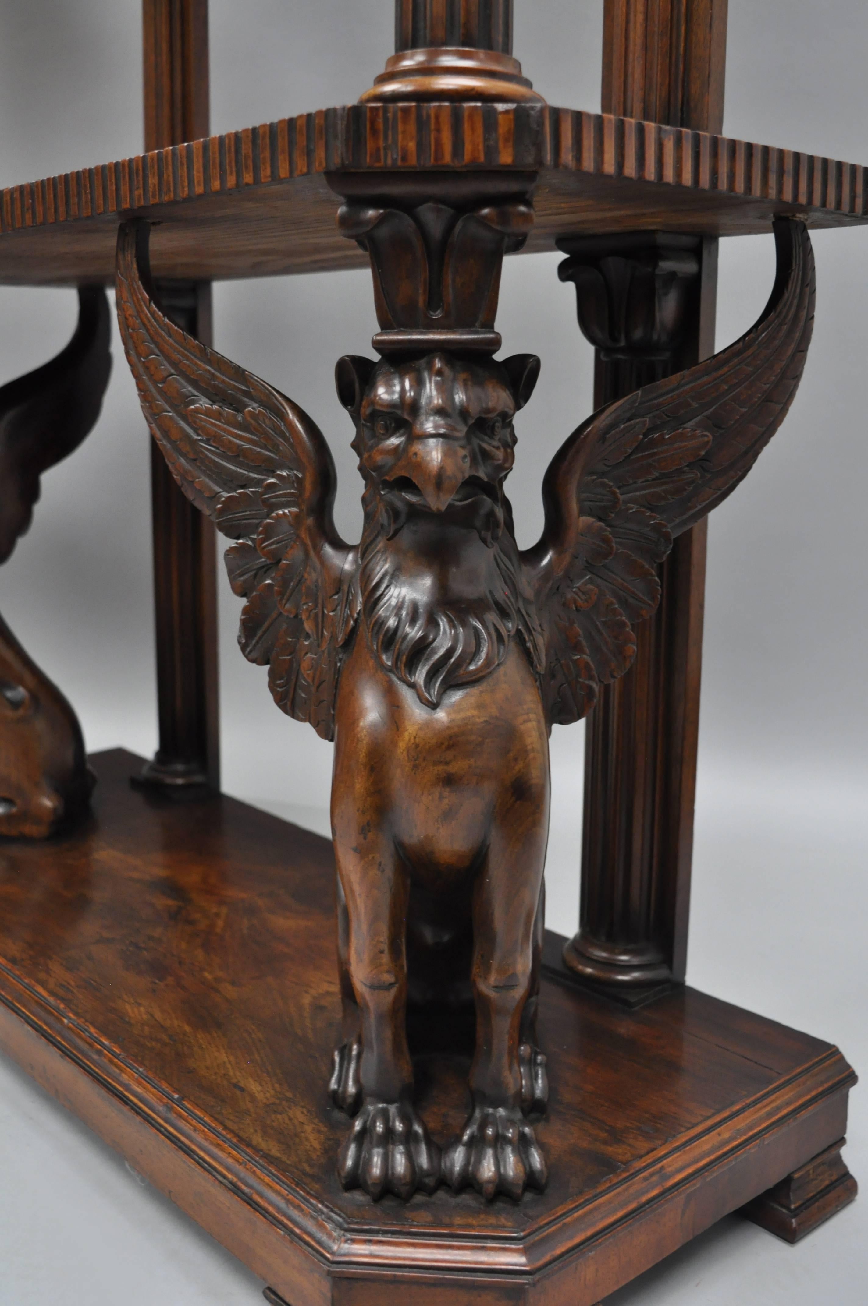 A Pair of Mahogany English Regency Style Carved Winged Griffin Whatnot Curio Stands in the R.J. Horner Style. The pair features finely detailed full figured winged griffins, pierce carved gallery, column supports, beautiful crotch mahogany wood