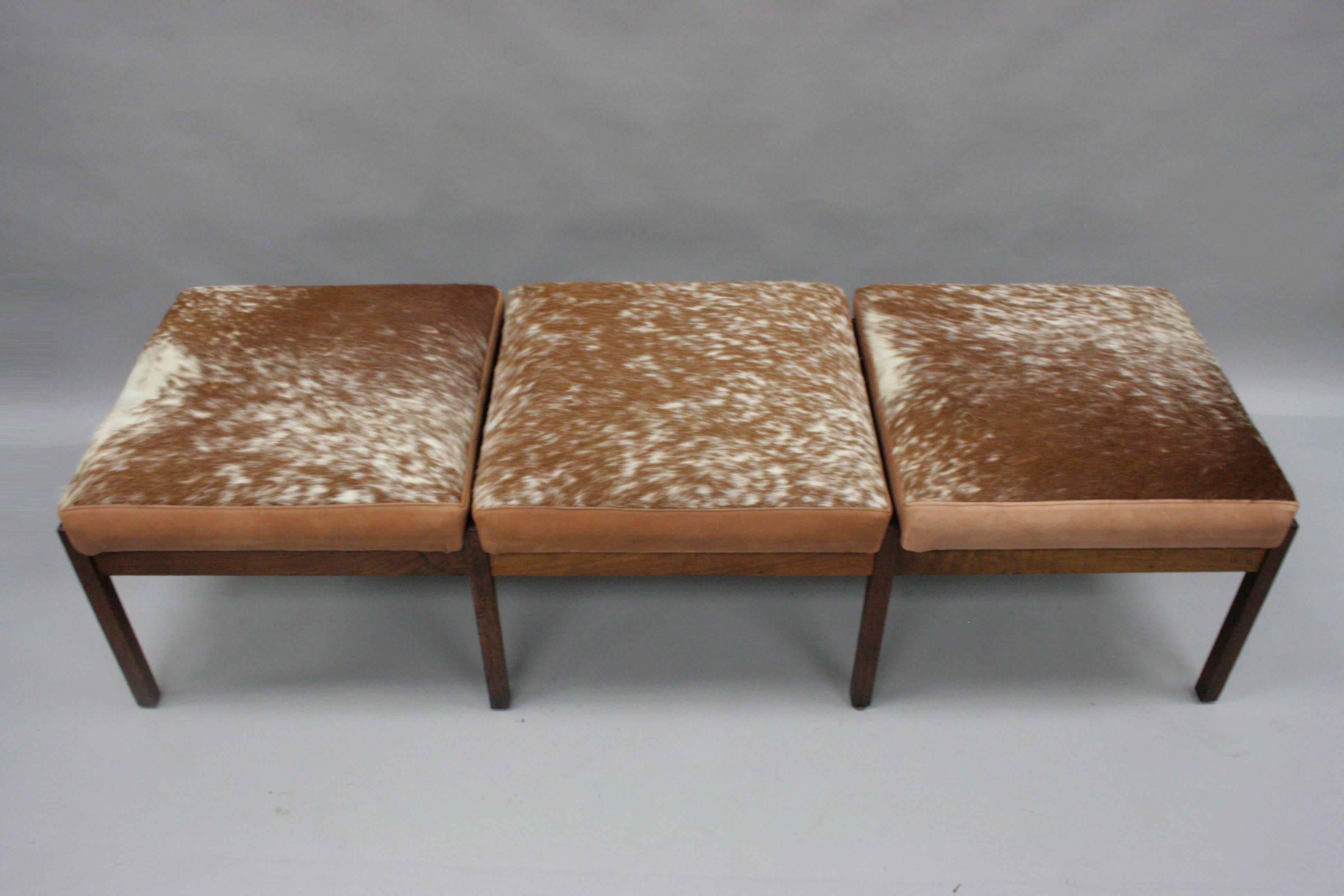 Vintage Danish modern eight-leg solid teak wood three-seat bench with hair on hide leather upholstery and clean modernist lines. The designer is unconfirmed but the quality and form is similar to the works of Hans J Wegner and Johannes Andersen.