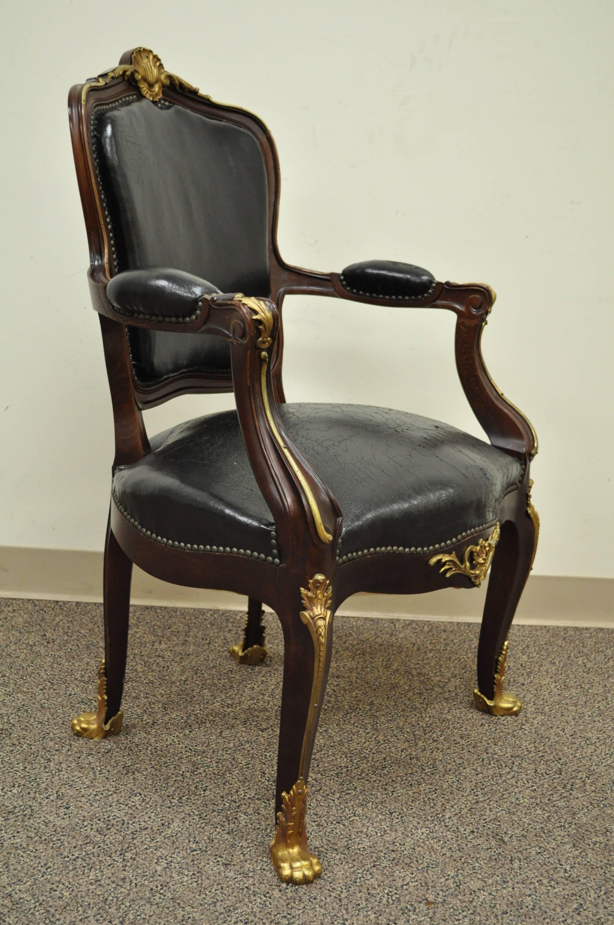 The finest Spanish made solid dark walnut armchair in the French Louis XV taste. Chair is nicely carved with a shapely form and delicate lines, and is further accented with cast bronze paw feet on the front and rear, central shell ornament, acanthus