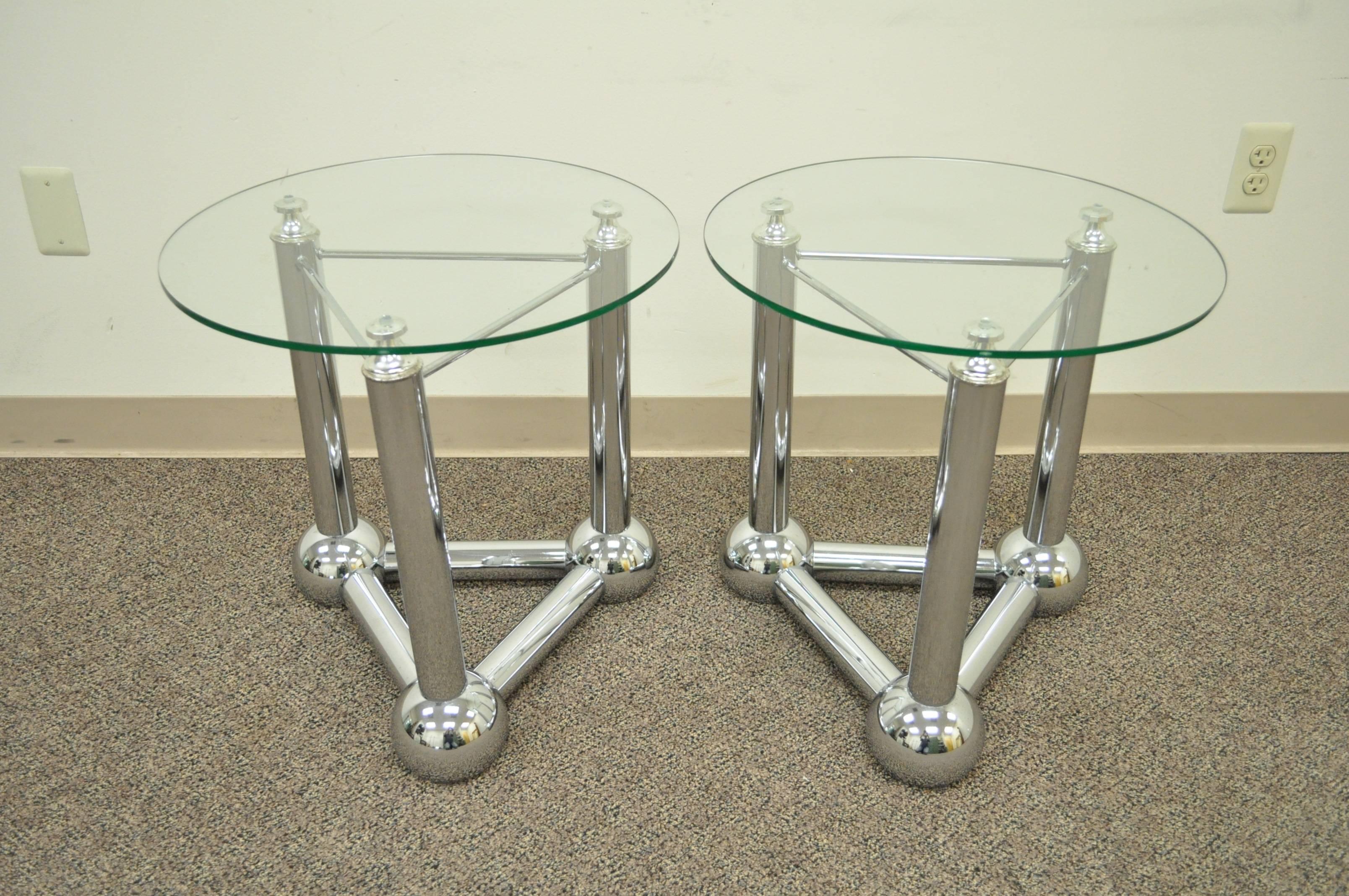 Pair of Vintage Mid Century Modern triangular base atomic form side tables. The pair features tubular chrome frames with a triple orb base and round glass tops. A very unique and interesting design that would make a great addition to any modern