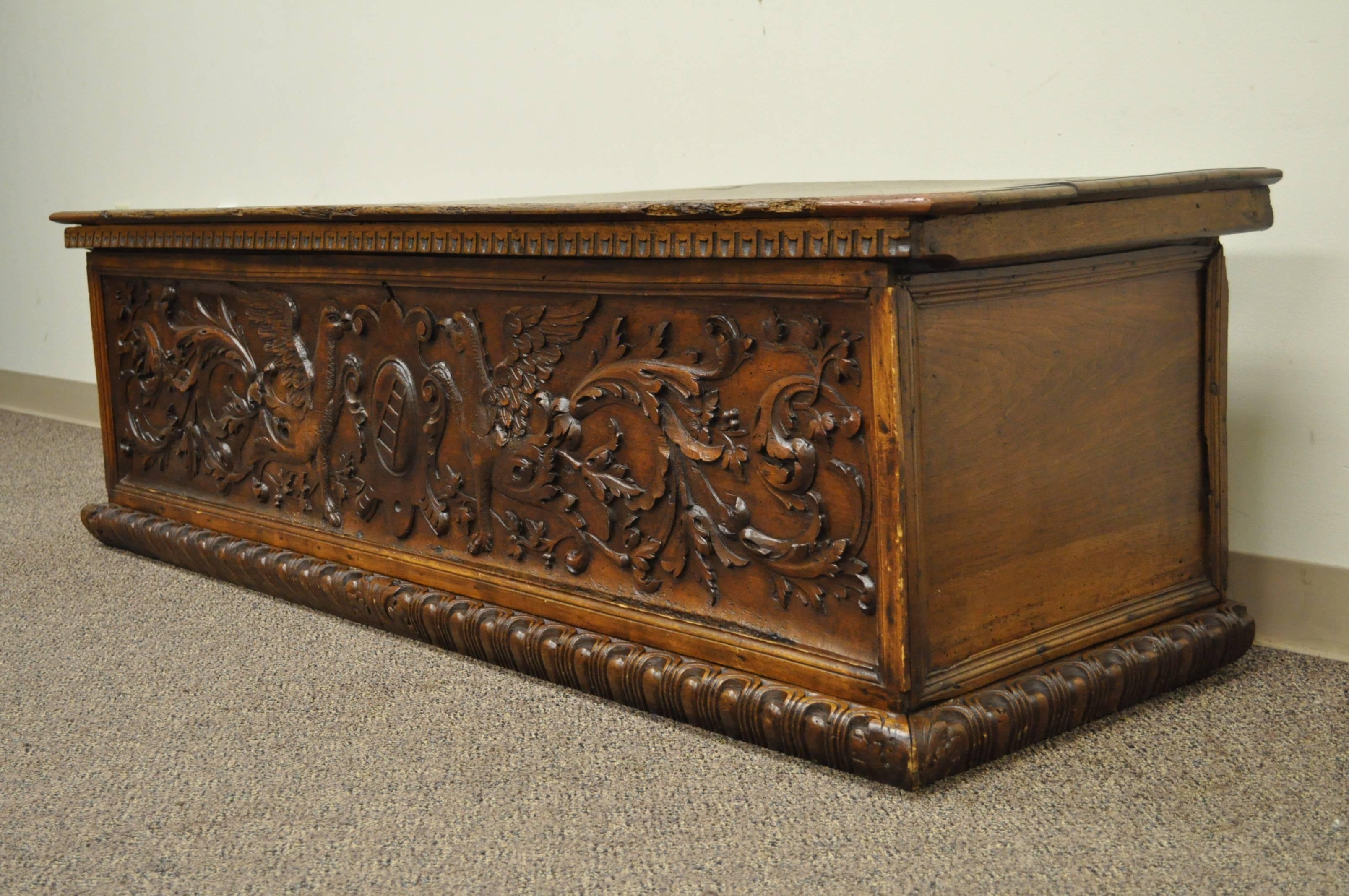 Large Gothic coffer / bench, believed to date back to the 1600s. Item features ornate, hand-carved, detailing on the front panel, a very thick and solid carved wood lid and an attractive and desirable patina/weathering and wormholes to the wood from