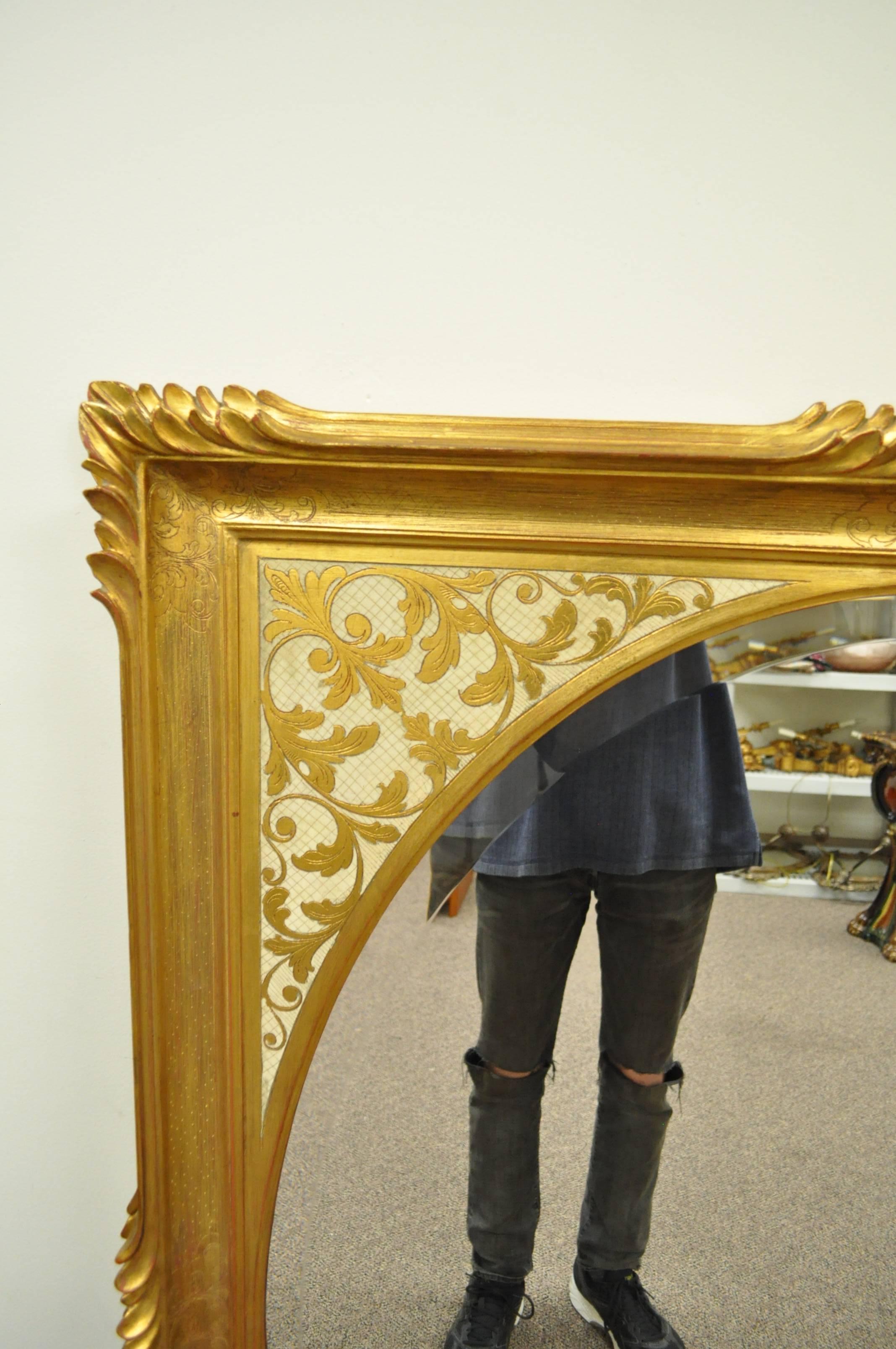 Beautiful 1960s Italian florentine carved wood wall mirror. Item features a cream and gold gilt finish, carved acanthus frame, oval beveled glass central mirror, and great overall form. Hardware can be added to hang the mirror vertically or