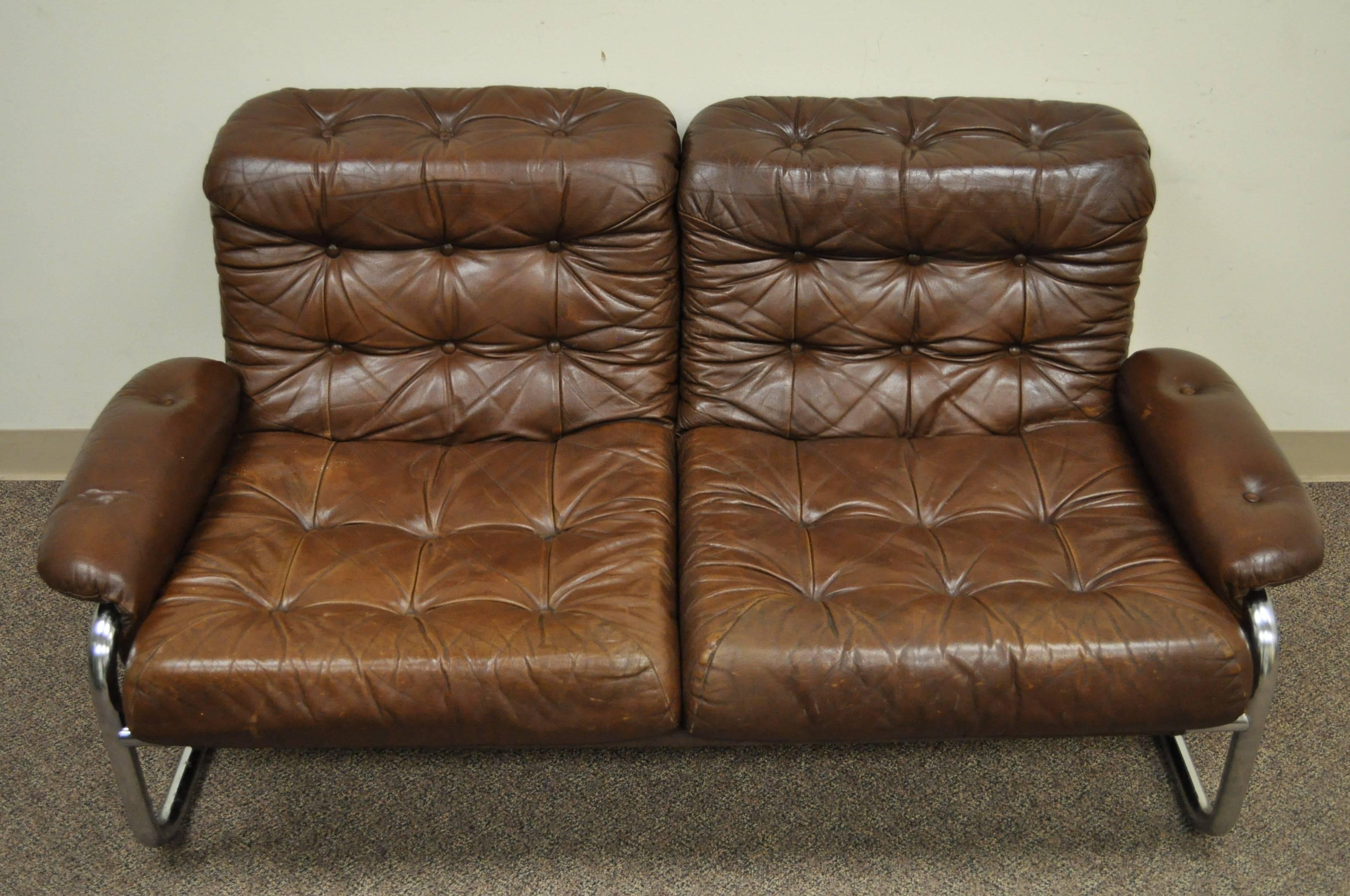 Vintage tubular chrome and brown tufted leather loveseat/settee. Item features a unique and shapely chrome frame with rolled arms and back and comfortable form. Maker is unconfirmed but reminiscent of the works of Rodney Kinsman.