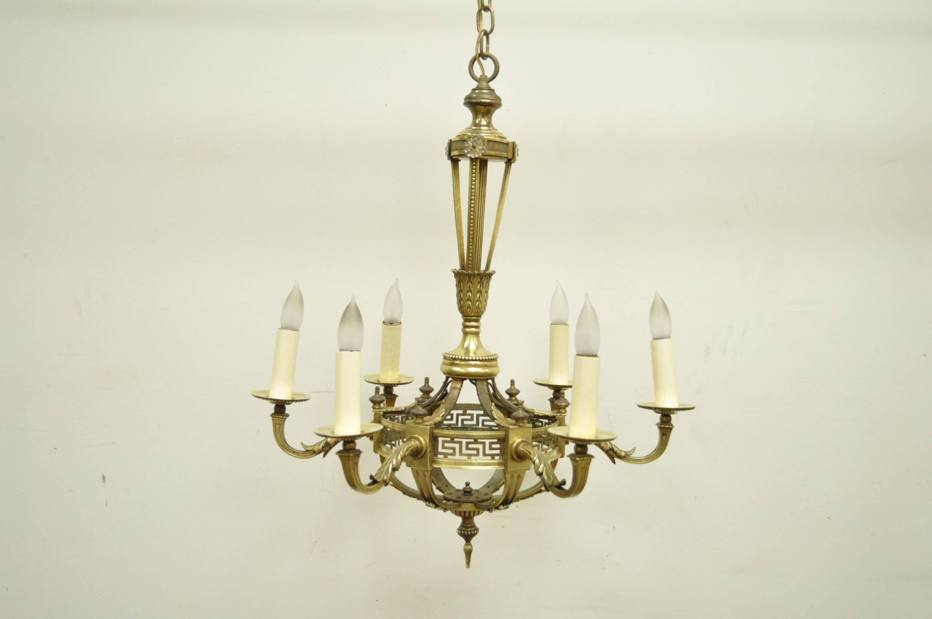 Elegant French neoclassical style, six-light, bronze chandelier. Item features a basket form frame, glass floral medallions at the top of the central shaft, cast bronze acanthus detailing and pierced Greek Key designs around the basket.