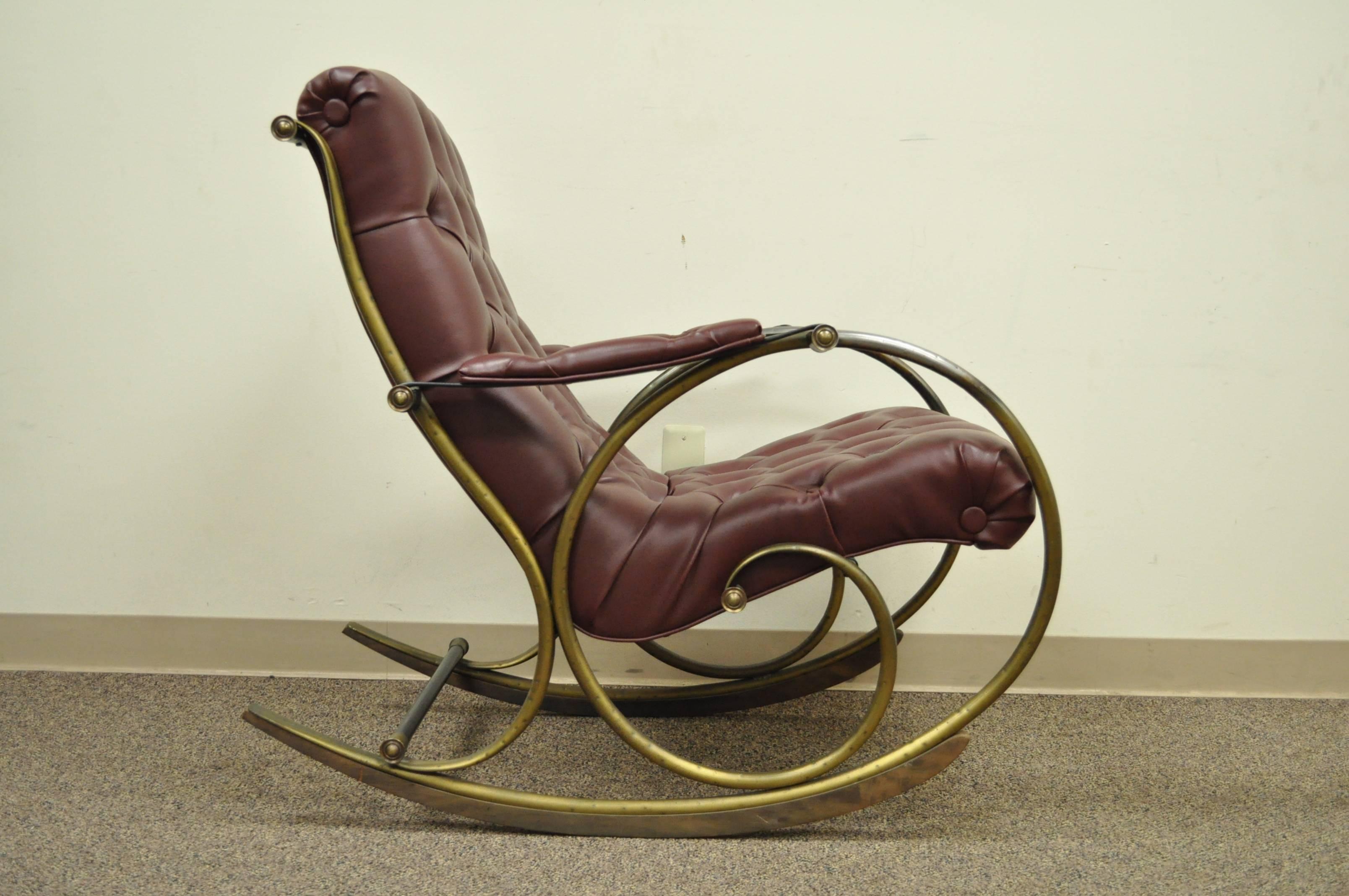 Lovely Mid-Century rocking chair designed by Lee Woodard. The chair frame is bent and hammered tubular brass, with wooden rockers. Upholstered in a tufted oxblood vinyl.