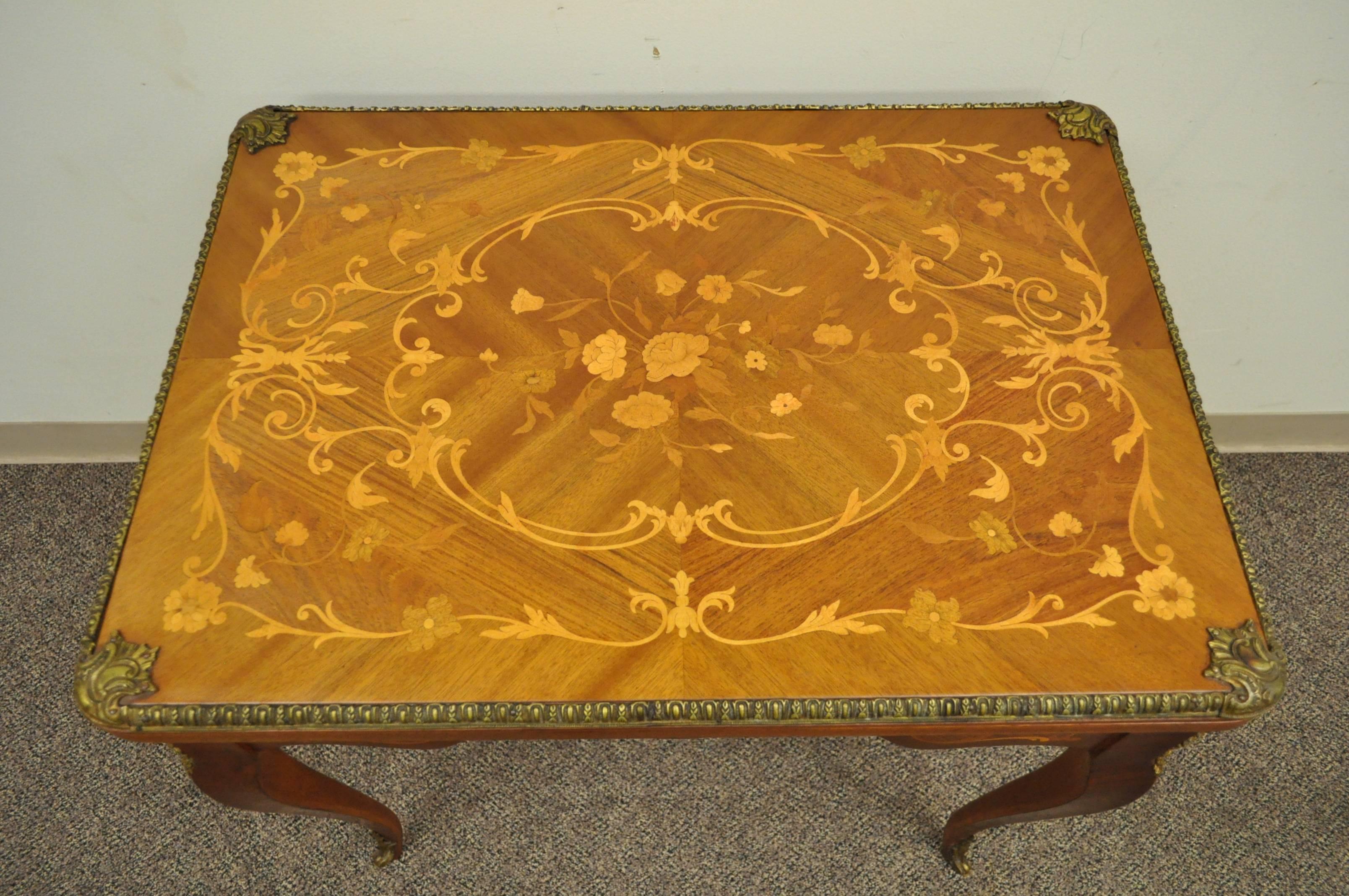 Eine schöne Französisch Louis XV-Stil Intarsien Flip-Top Spieltisch. Der Tisch hat ein wunderschönes florales Intarsienmuster auf der Platte und allen Seiten, gegossene Bronzebeschläge und eine einzelne Schublade mit Schwalbenschwanz.

Die