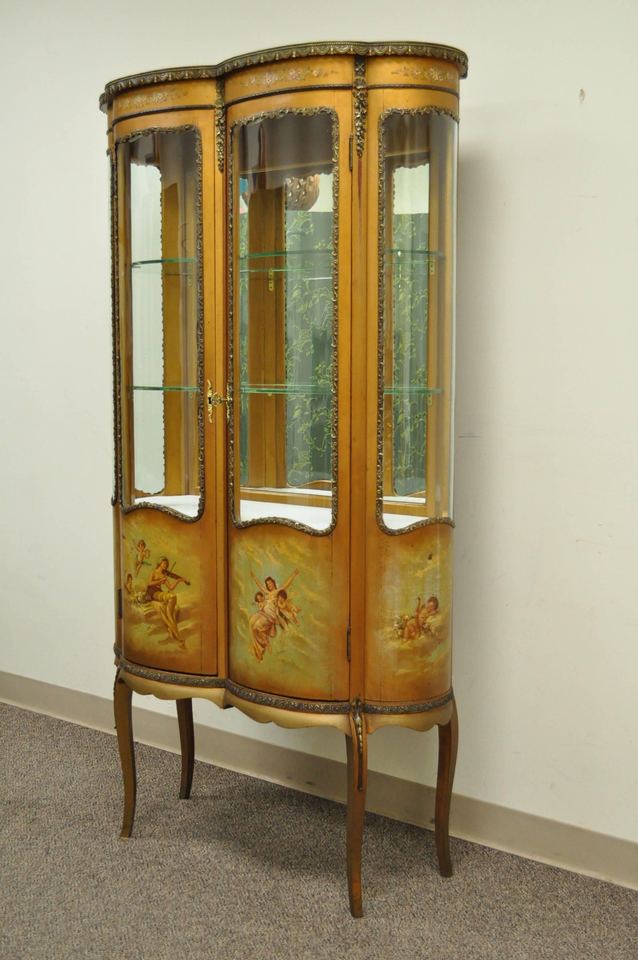 Stunning antique Louis XV style Vernis Martin display cabinet. The French cabinet features four curved glass panels, hand-painted details with angels and muses, intricate bronze-mounted ormolu, mirrored backing, lighted interior and a wonderful