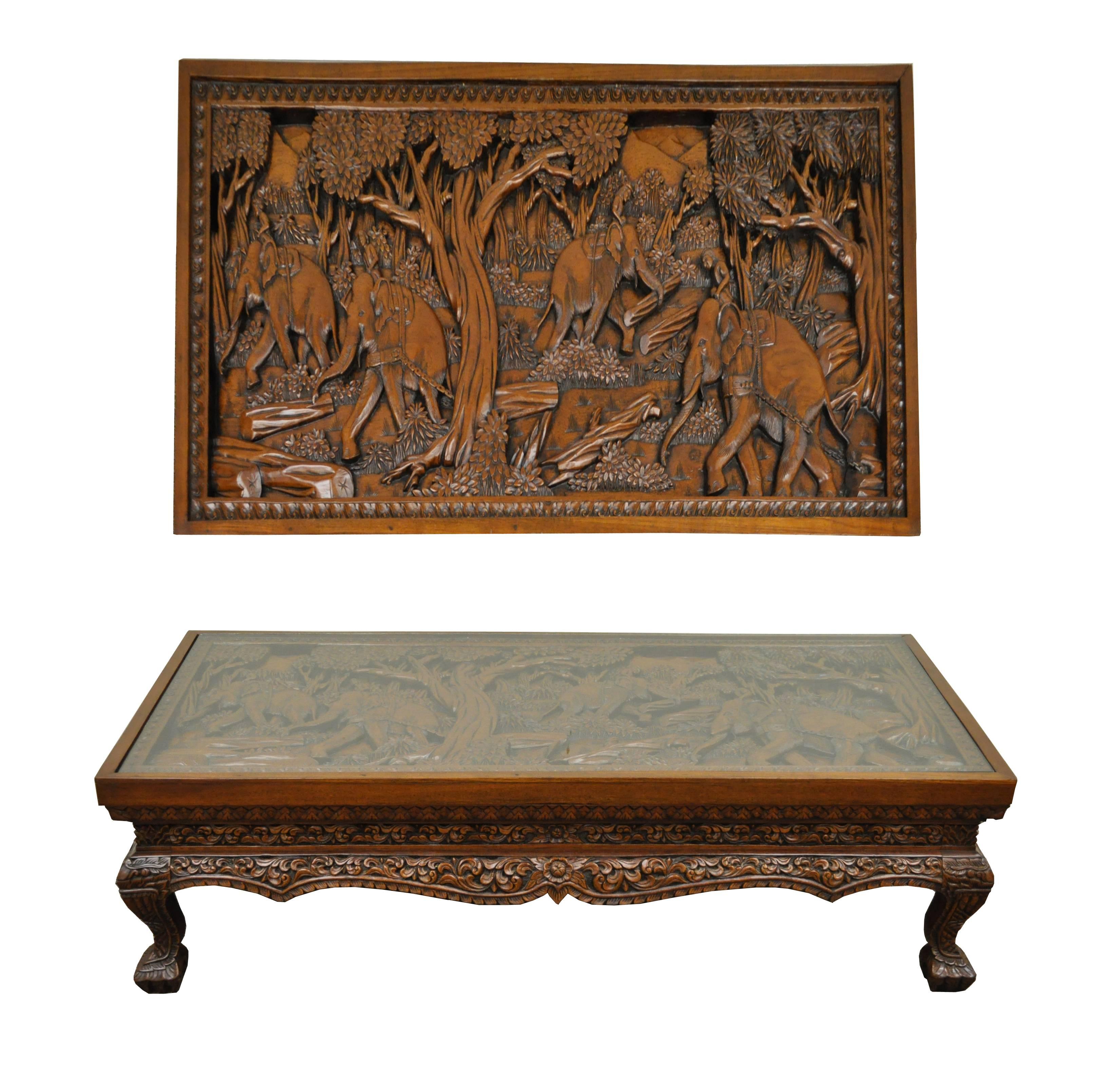 Inset glass top deep relief carved Vietnamese low table. Heavily carved throughout depicting elephants working in a forest. Very nicely done with figural carved legs/feet and floral acanthus carved skirt. Believed to be solid teak wood or solid