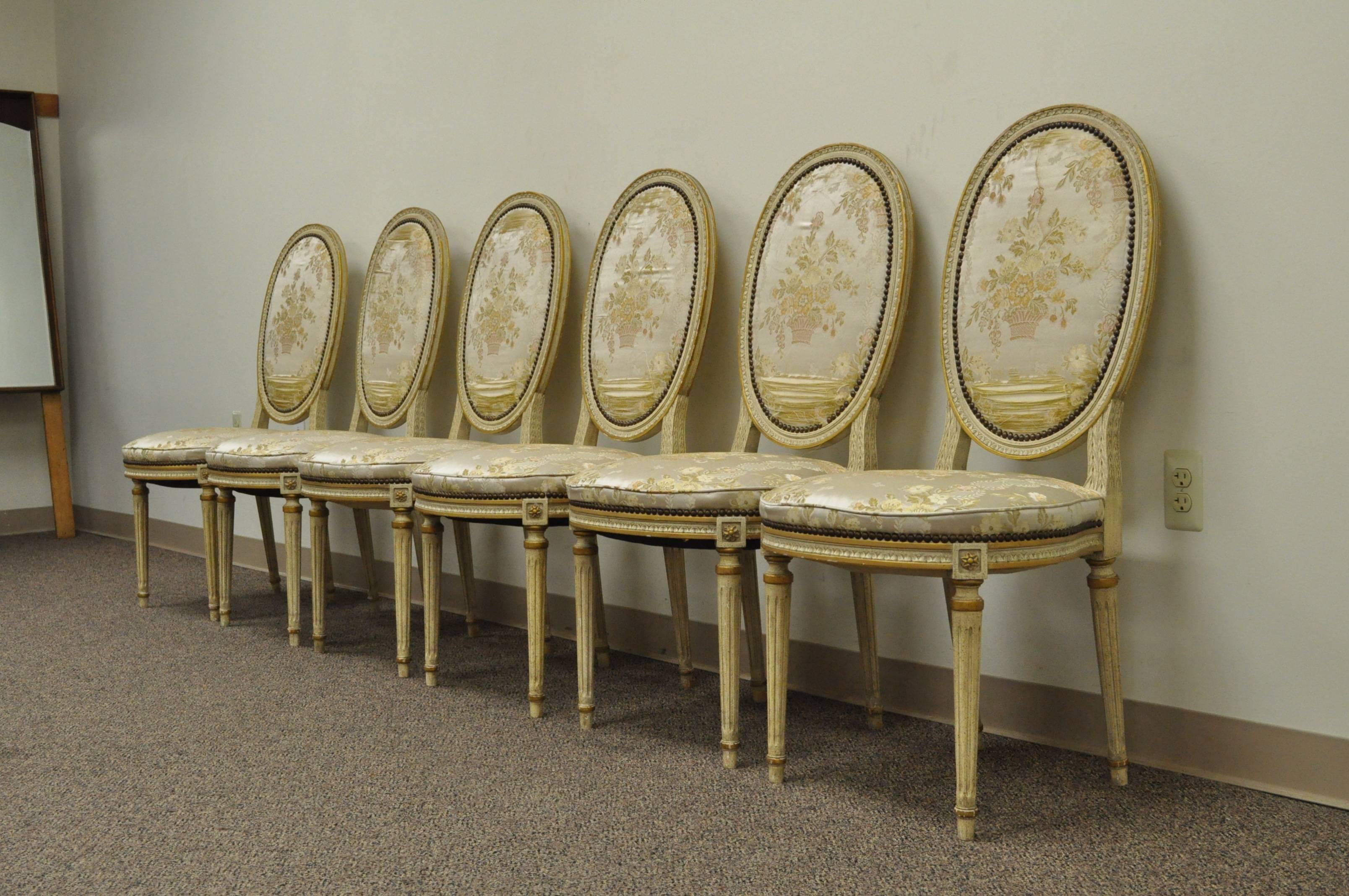 Remarkable set of 6 French Louis XVI Style Dining Chairs. Chairs features reeded and tapered legs, medallion backs, carvings to the frames, and upholstered backs and seats. 