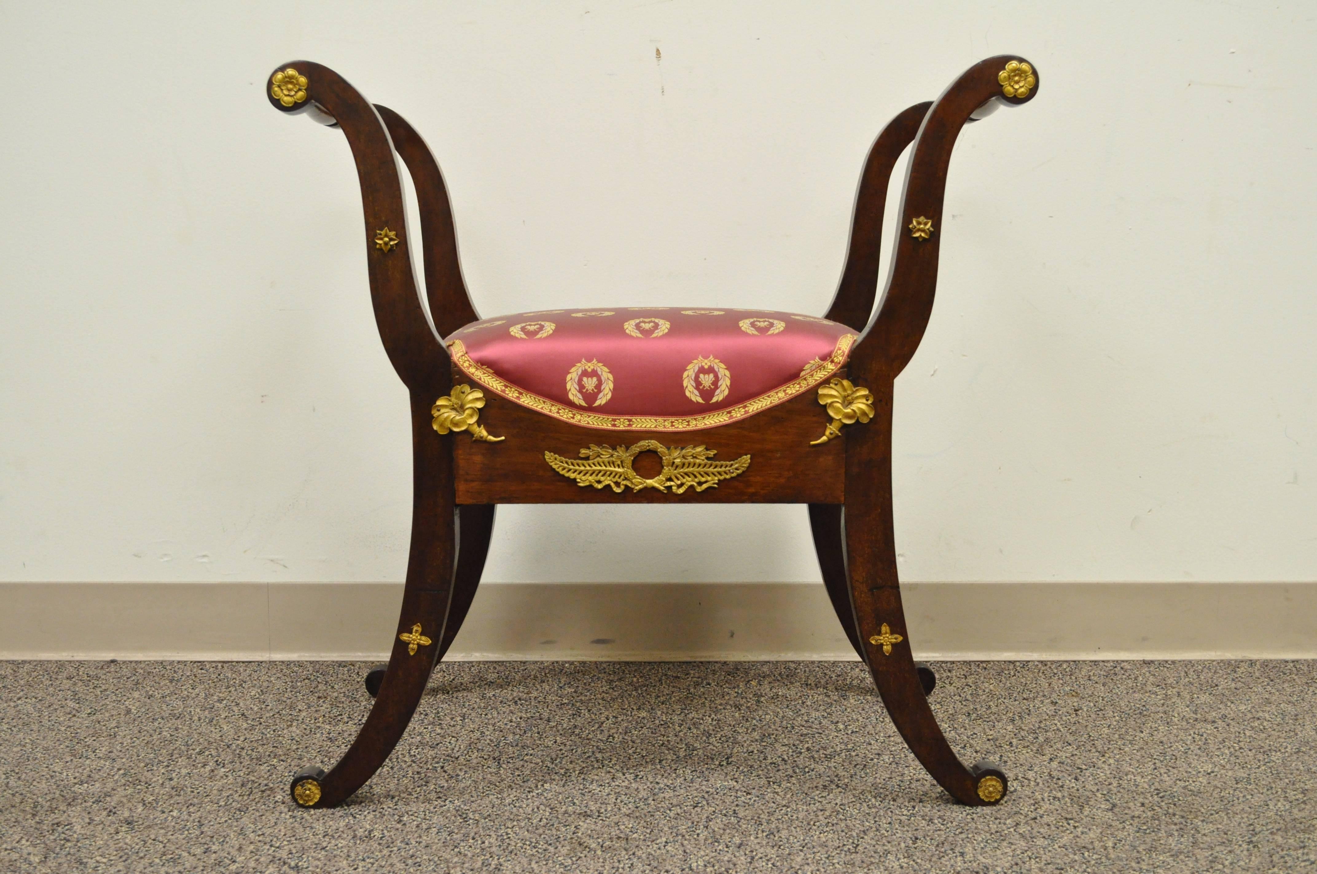 Fantastic 19th century Curule form French neoclassical bench with bronze mounts on all four sides. Item features a solid mahogany frame, classical bronze mounted ormolu all the way around and very elegant form. Newer upholstery.