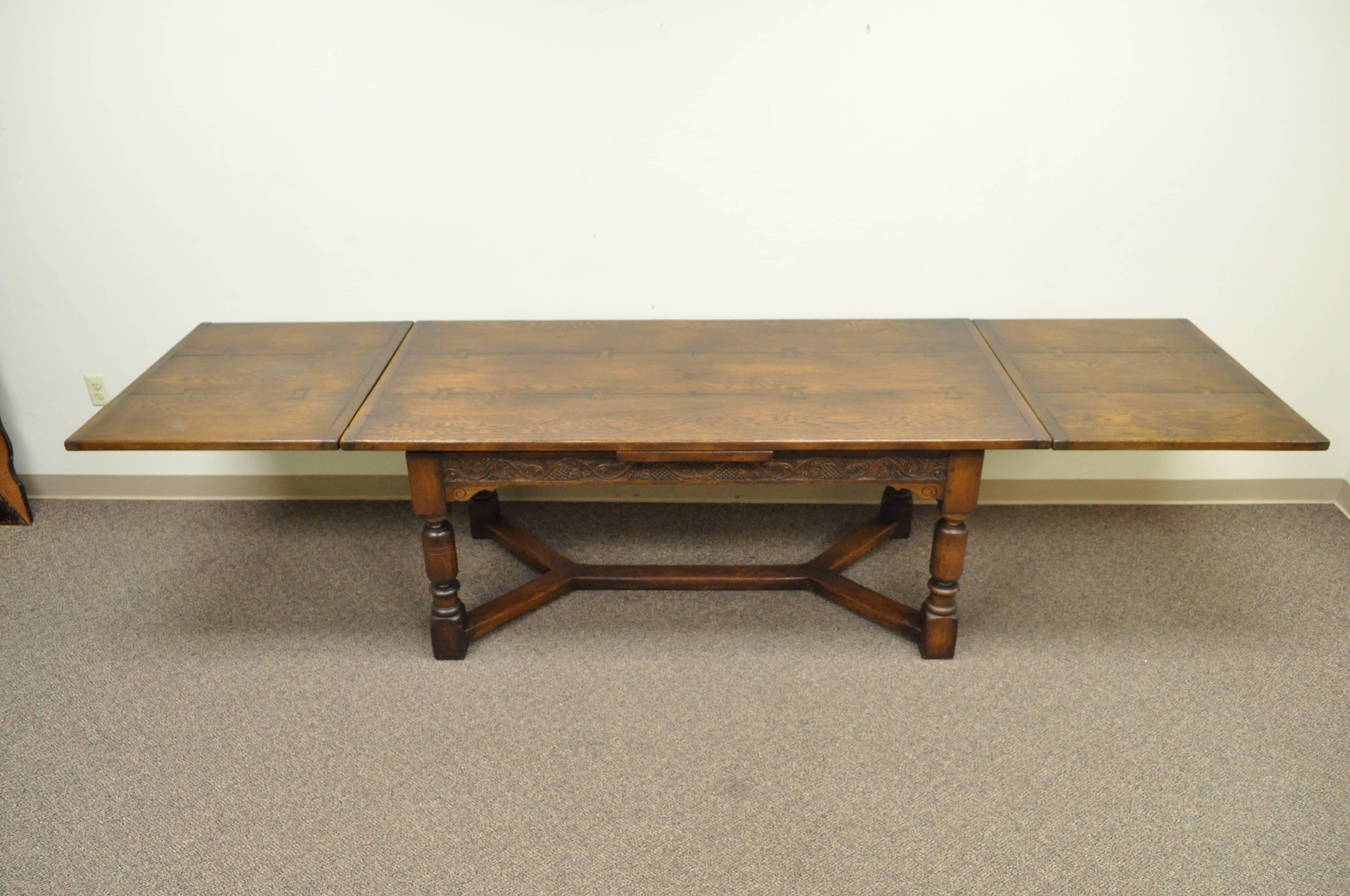 Beautiful English, Solid Oak, Jacobean Style Extension Dining Table. Item features two pull out extension leaves, ornately carved skirt, stretcher supported base, turned legs, decorative buttefly/bowtie joints on the top, and great overall form.