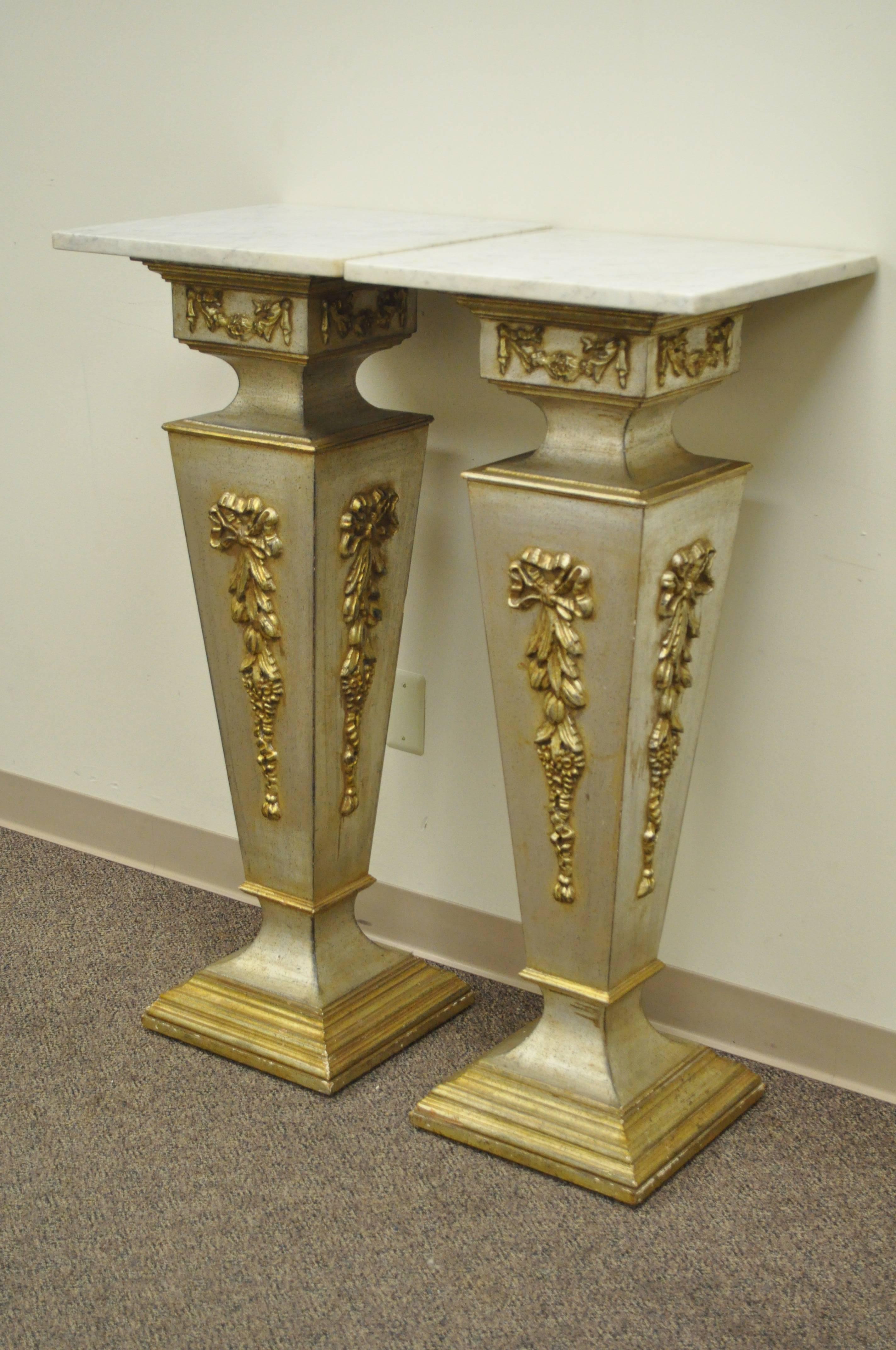 Pair of 20th Century Italian Florentine Marble Top Pedestals, Bust Tables. The pair features rounded edge square white marble tops, beautiful floral drape detailing on all sides, and an attractive gold, silver gilt leaf finish.