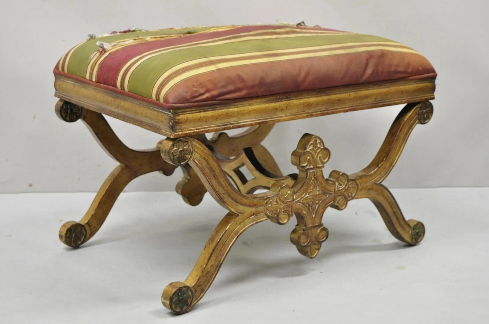 Vintage Spanish Regency Spanish Regency Carved Wood X-Frame Gold Upholstered Stool Bench. Cet article se caractérise par une construction en bois massif, une finition dorée vieillie, des détails joliment sculptés, un style et une forme remarquables.