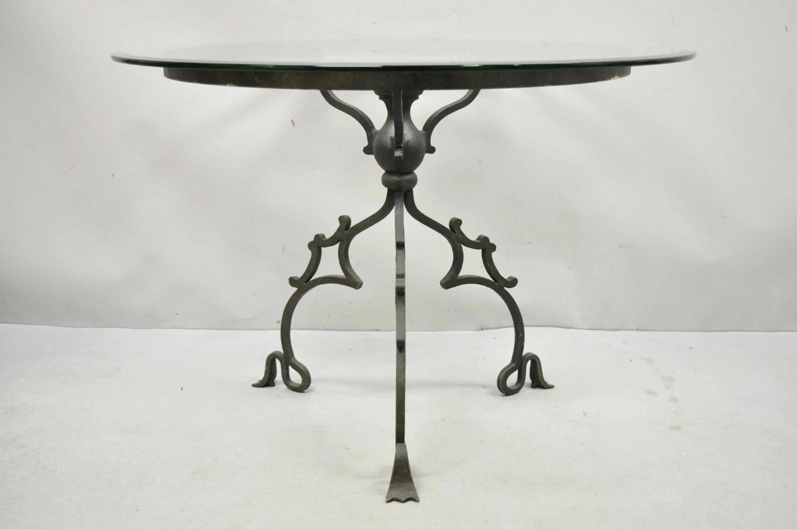 Vintage Gothic Style Wrought Iron Scrolling Base Round Glass Top Center Table. Item features an ornate wrought iron scrolling gothic style base, round glass top, quality craftsmanship, great style form, base alone 50 lbs. Circa Mid 20th Century.