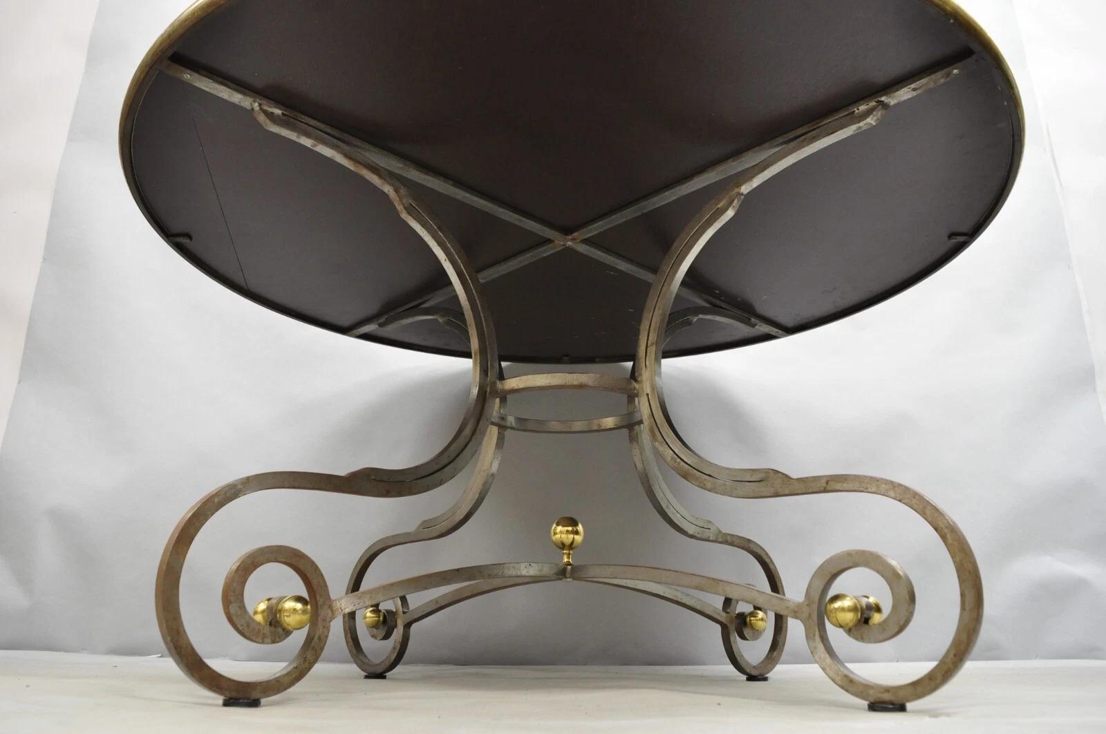 Table de salle à manger vintage de style néoclassique français à volutes en acier et bronze attribuée à la Maison Jansen. L'article se caractérise par une lourde base en acier de haute qualité avec des fleurons en forme de boule en laiton, et par un