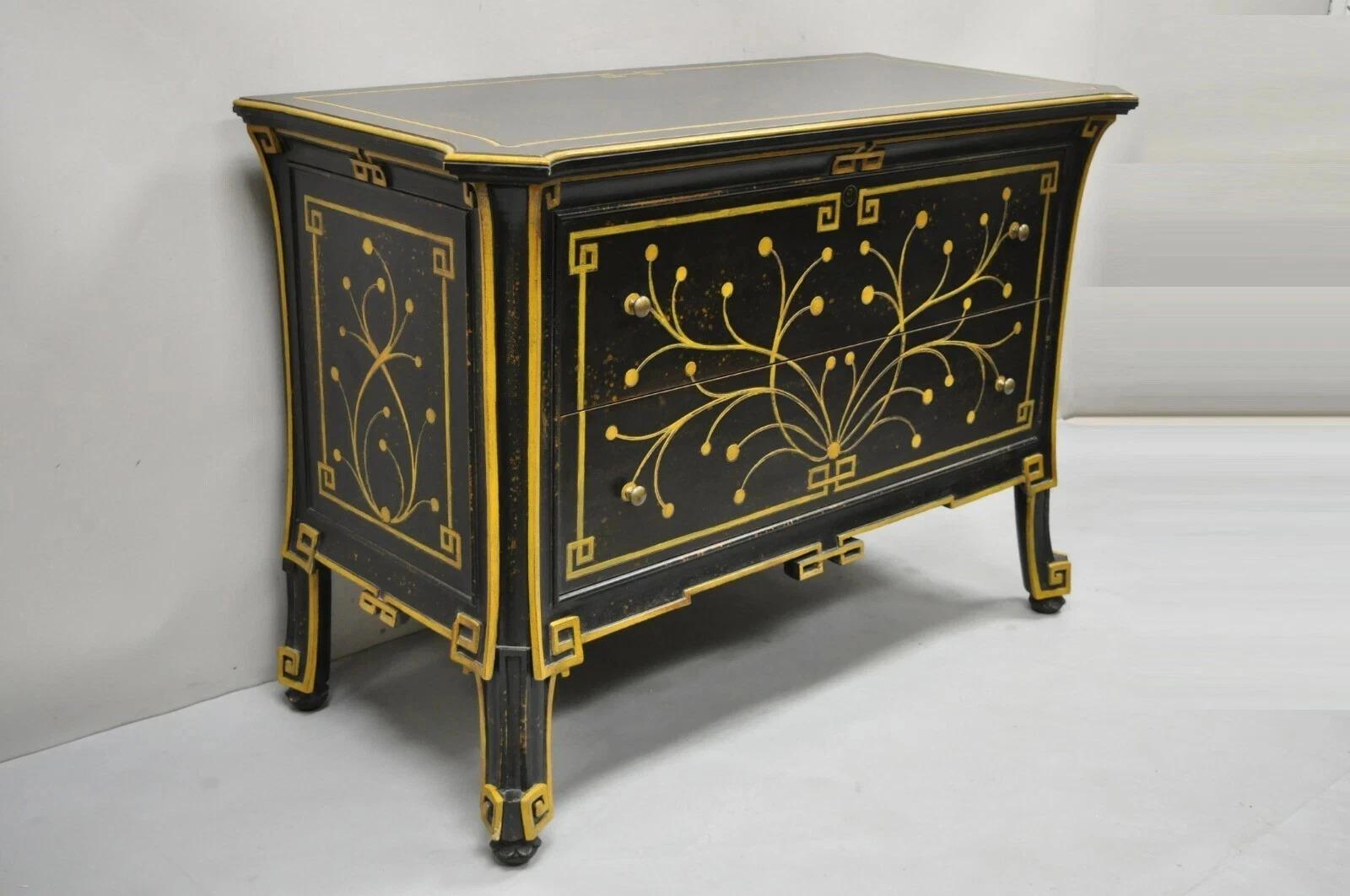Comò a 2 cassetti in stile Regency nero ebanizzato di Decorative Crafts. L'oggetto presenta un design a volute dipinto in oro, una finitura ebanizzata dipinta in nero, un piano sagomato, un'etichetta originale, nessuna chiave ma sbloccata, qualità