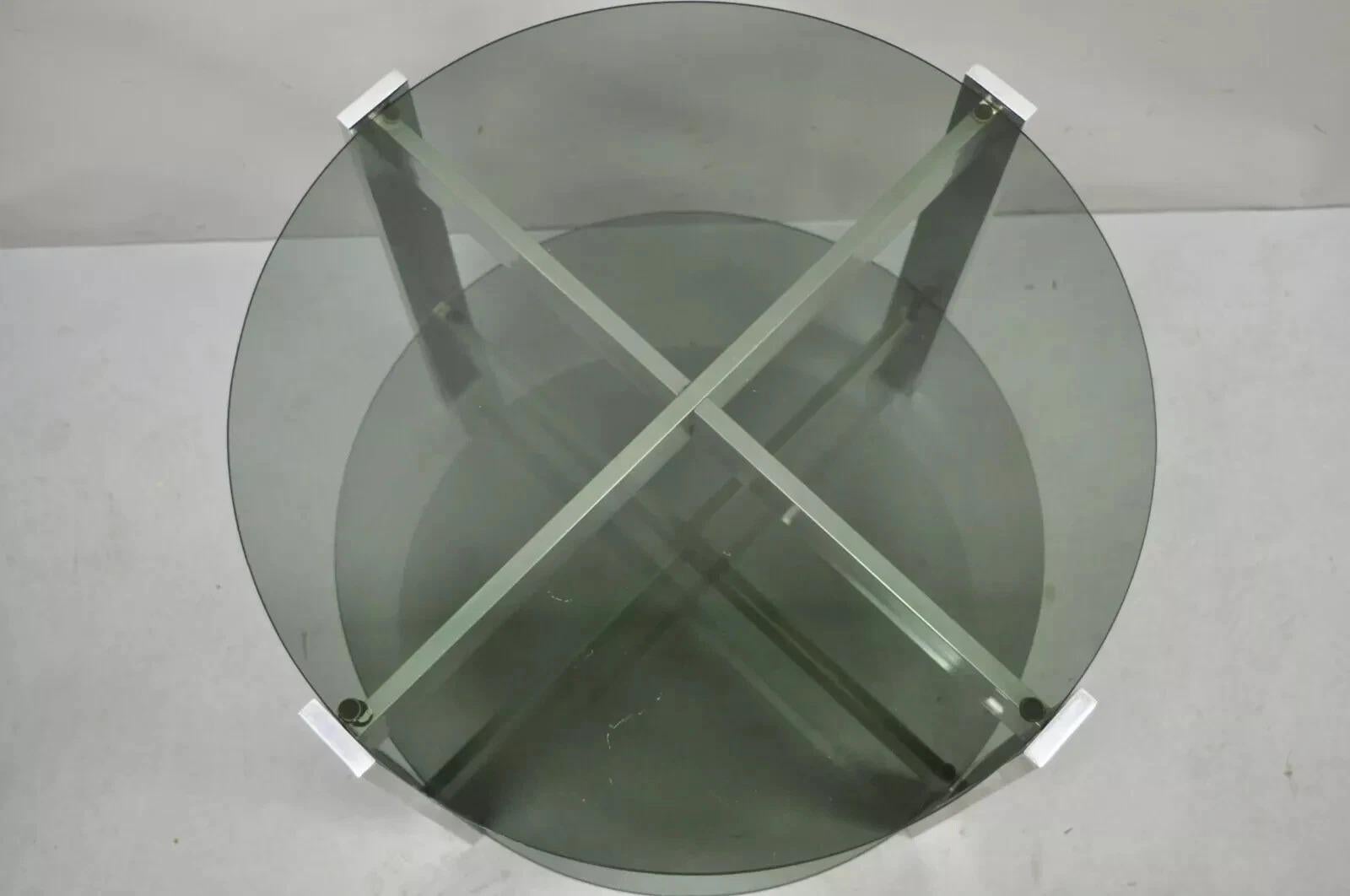Table d'appoint Vintage Mid Century Modern Round Smoked Glass 2 Tier Aluminum Base Side Table. L'article présente (2) plateaux ronds en verre fumé, un cadre en forme de x en aluminium moulé, un modernisme épuré, une fabrication de qualité, un style
