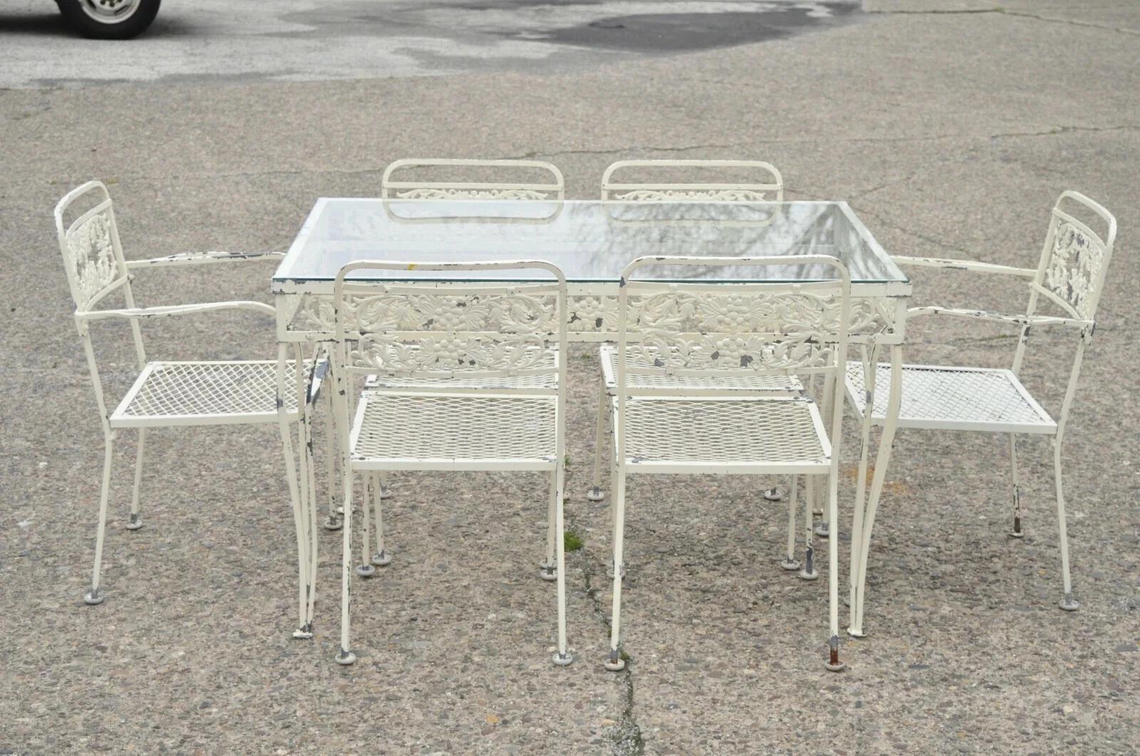 Please message us with your zip code to request a more reasonable domestic U.S. shipping quote.

Vintage Victorian Grapevine Wrought Iron Garden Patio Dining Set - 7 Pc Set. Listing includes (2) armchairs, (4) side chairs, (1) glass top table,