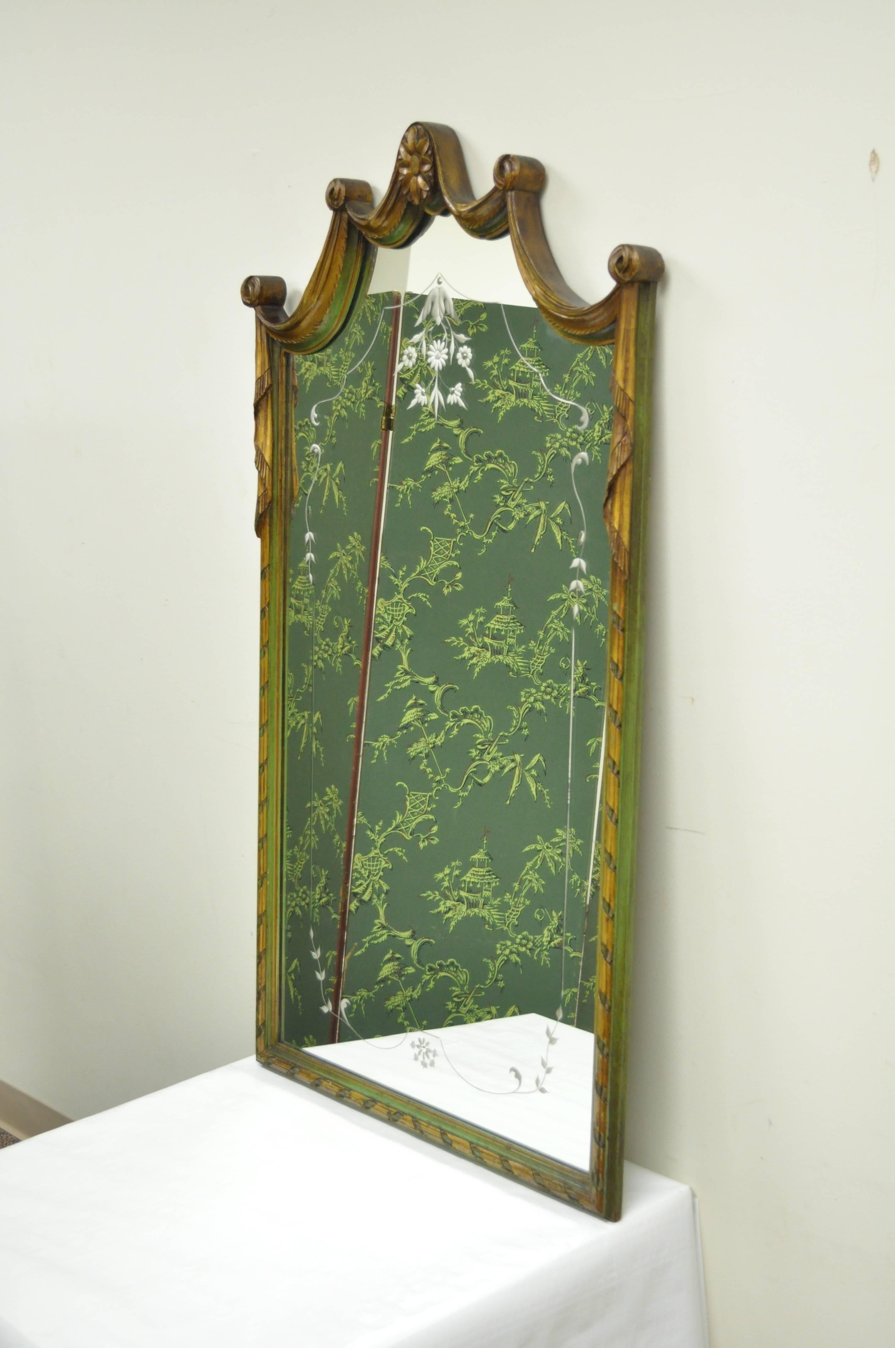 Early 20th century French Louis XV style green and gold carved wood etched glass wall mirror. Item features a solid carved wood frame with arched drape pediment, green and gold painted finish, and floral etched glass detailing to the mirror.
