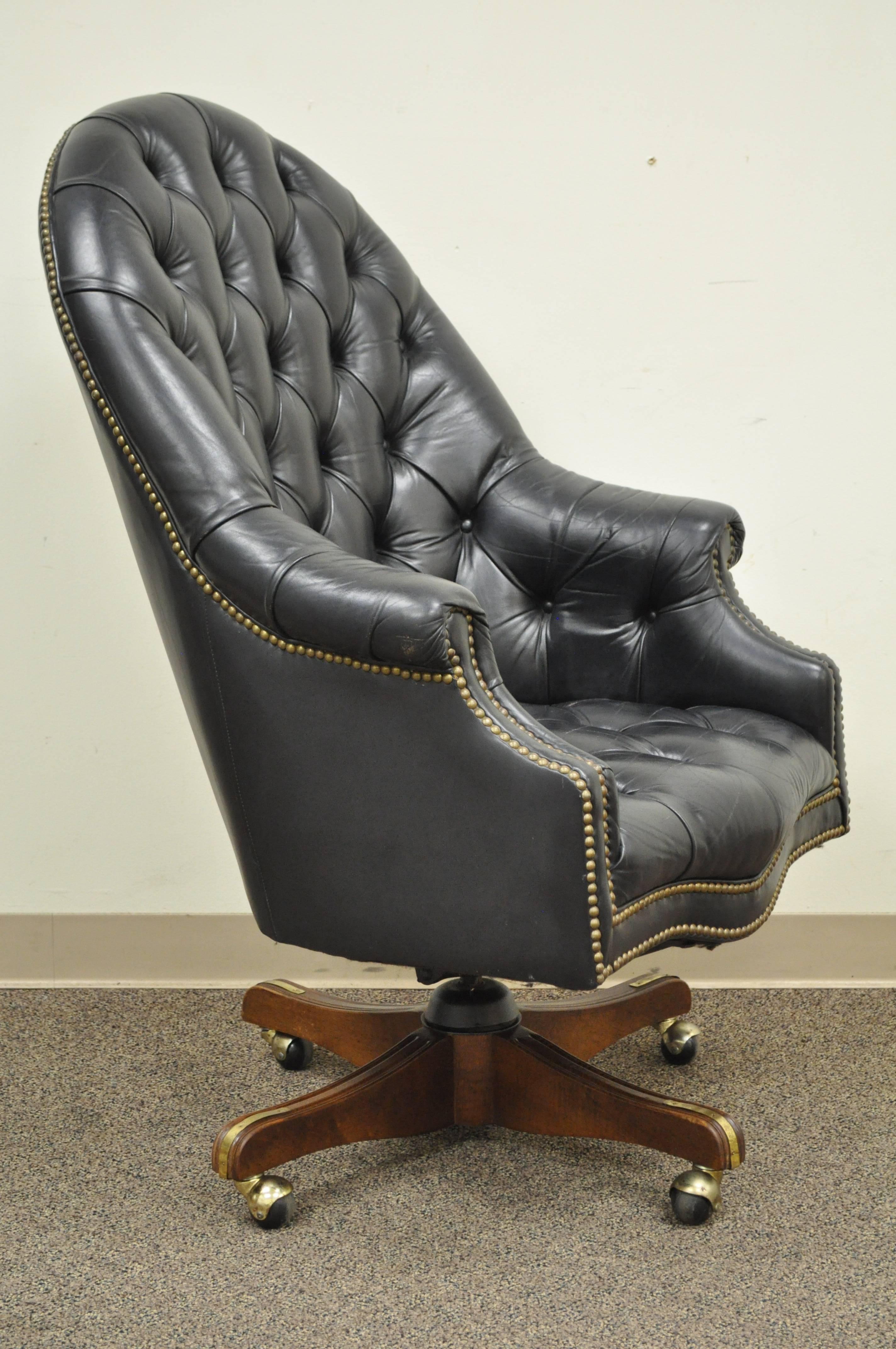 Vintage deep tufted black leather English Chesterfield style barrel back desk chair. Item features rolled arms, nailhead trim, deep button tufts, and a solid wood base on rolling casters. Leather has achieved a beautiful patina. Believed to be a