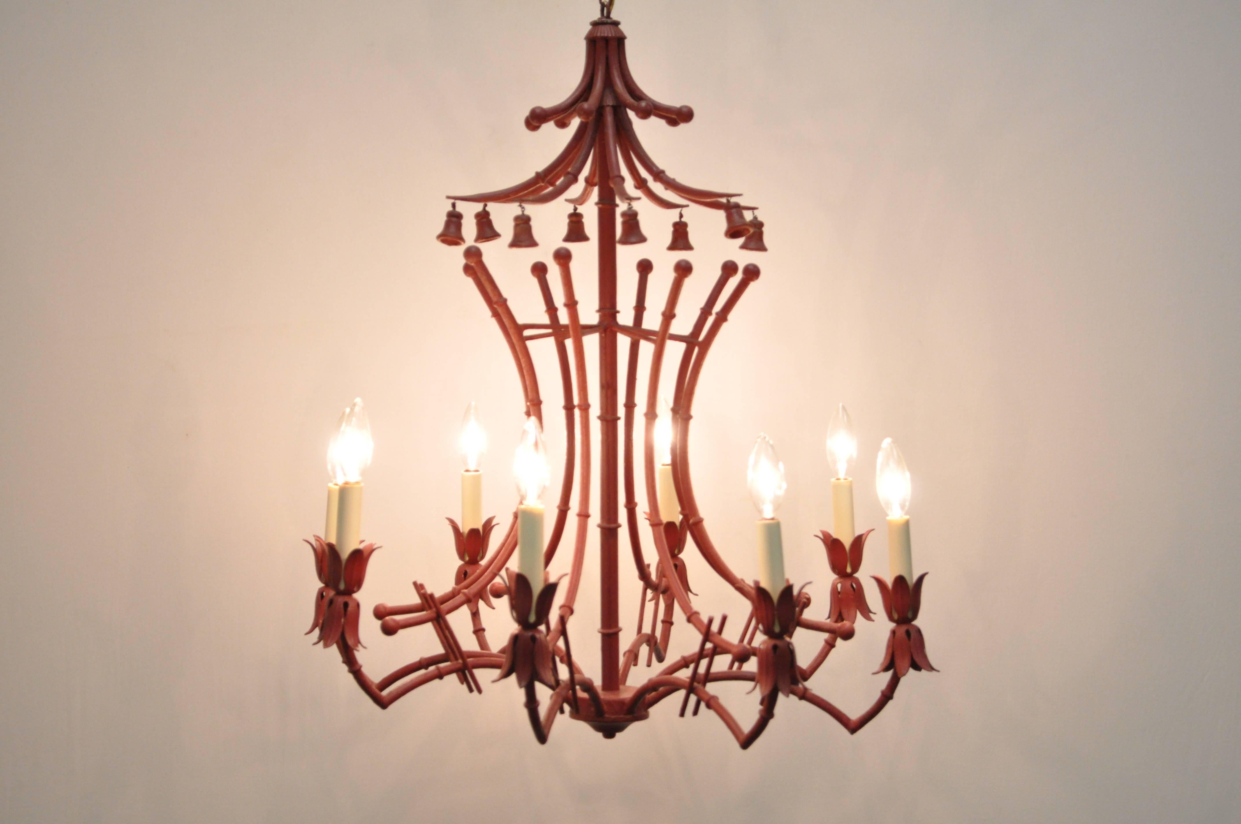 Fabulous vintage red painted Italian faux bamboo tole metal chandelier. Item features a unique pagoda frame with non-ringing bell accents, eight arms and lights, and Classic Chinese Chippendale form.