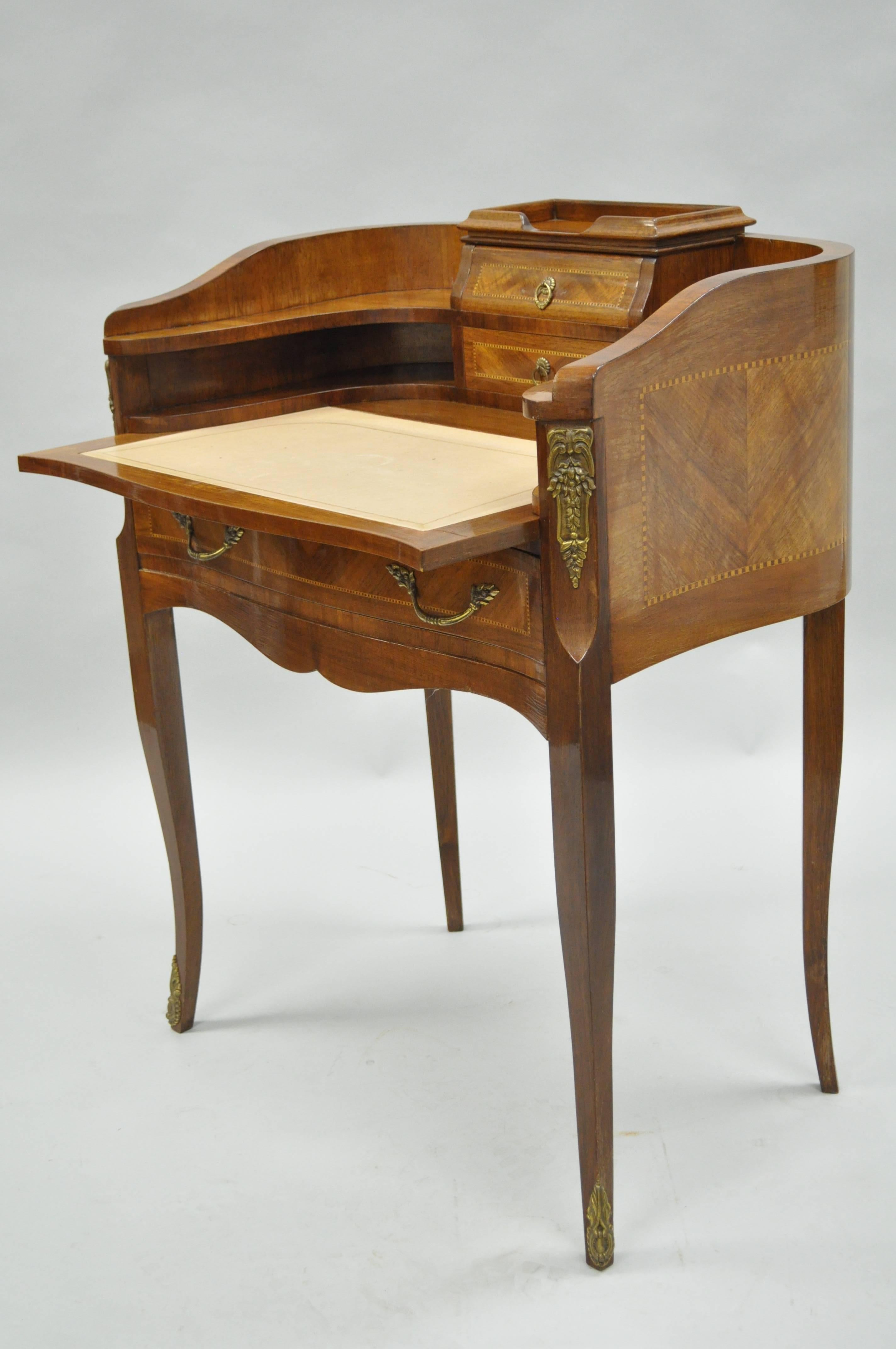 Vintage Petite Louis XV French style satinwood inlaid demilune form ladies writing desk. Item features a pull out leather top writing surface, bronze-mounted ormolu, parquetry inlaid back, and adorable petite form. 