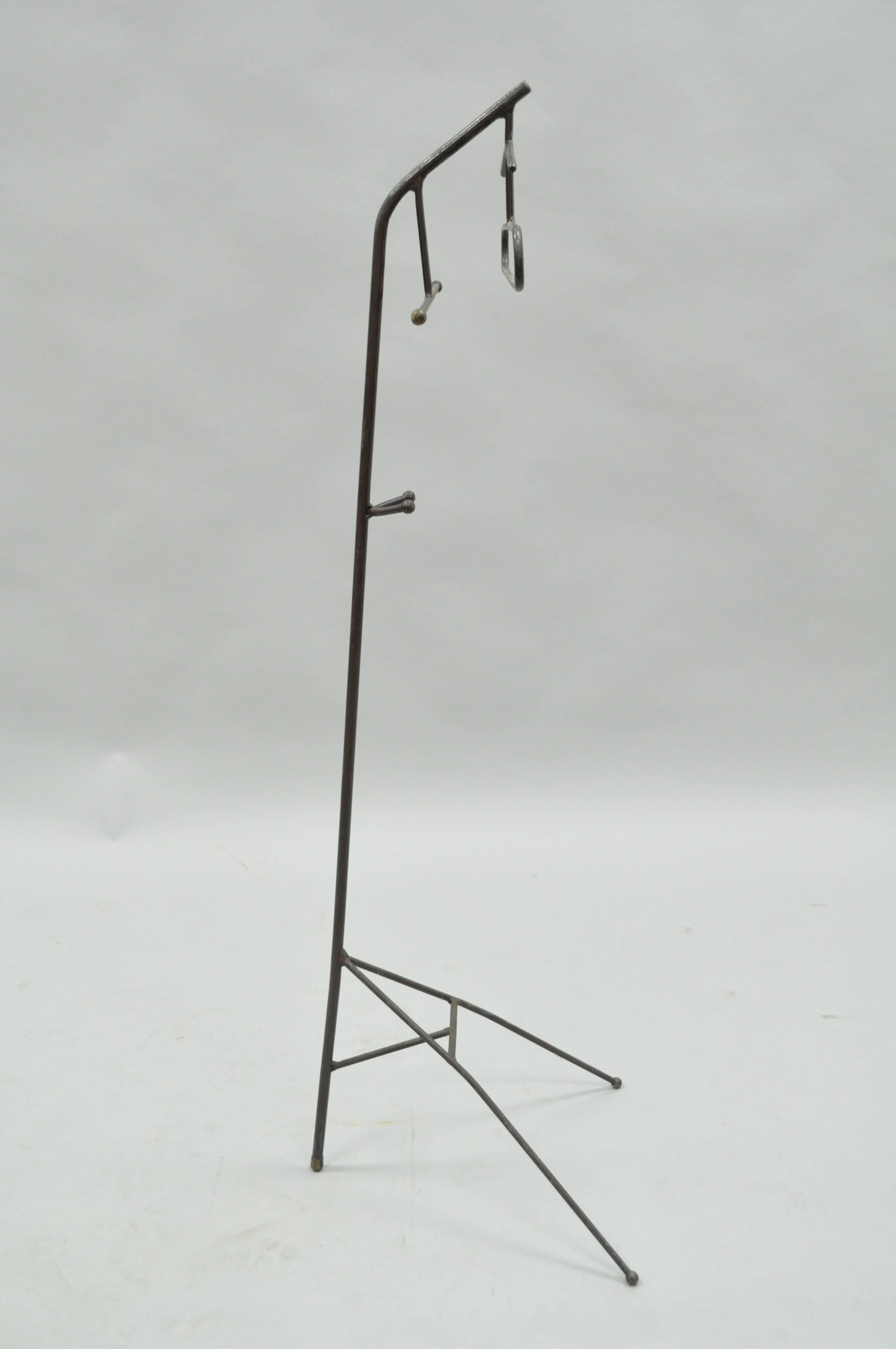 Unique vintage French Mid-Century Modern wrought iron and brass hairpin clothing or clothes valet in the manner of Jacques Adnet. Item features brass ball ends on the iron rods, clean modernist lines and great form. Item is constructed primarily of