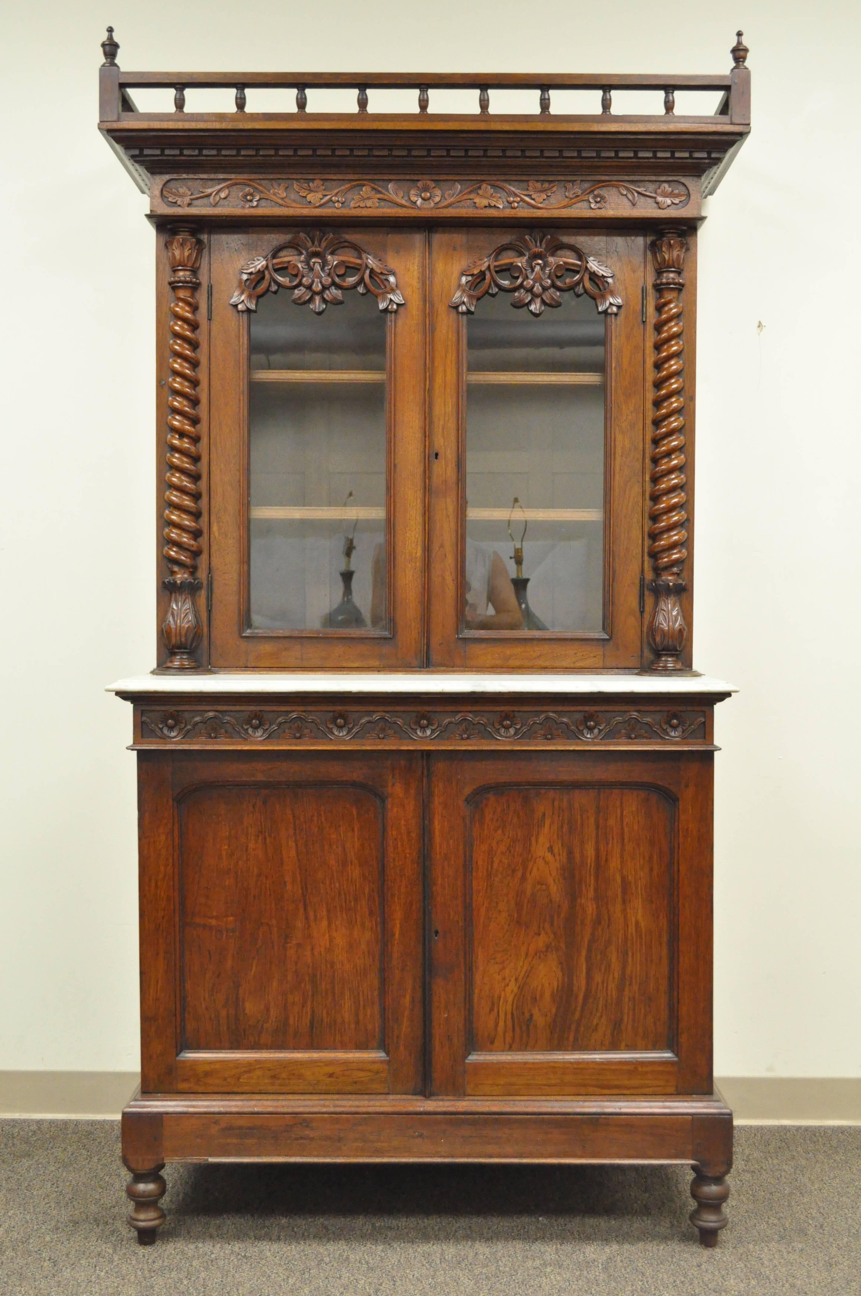 Remarkable 19th century French Renaissance Revival carved walnut marble top two-piece sideboard. Item features an ornately carved upper gallery, two upper glass front cabinet doors, twisted columns, two lower cabinet doors concealing two dovetail