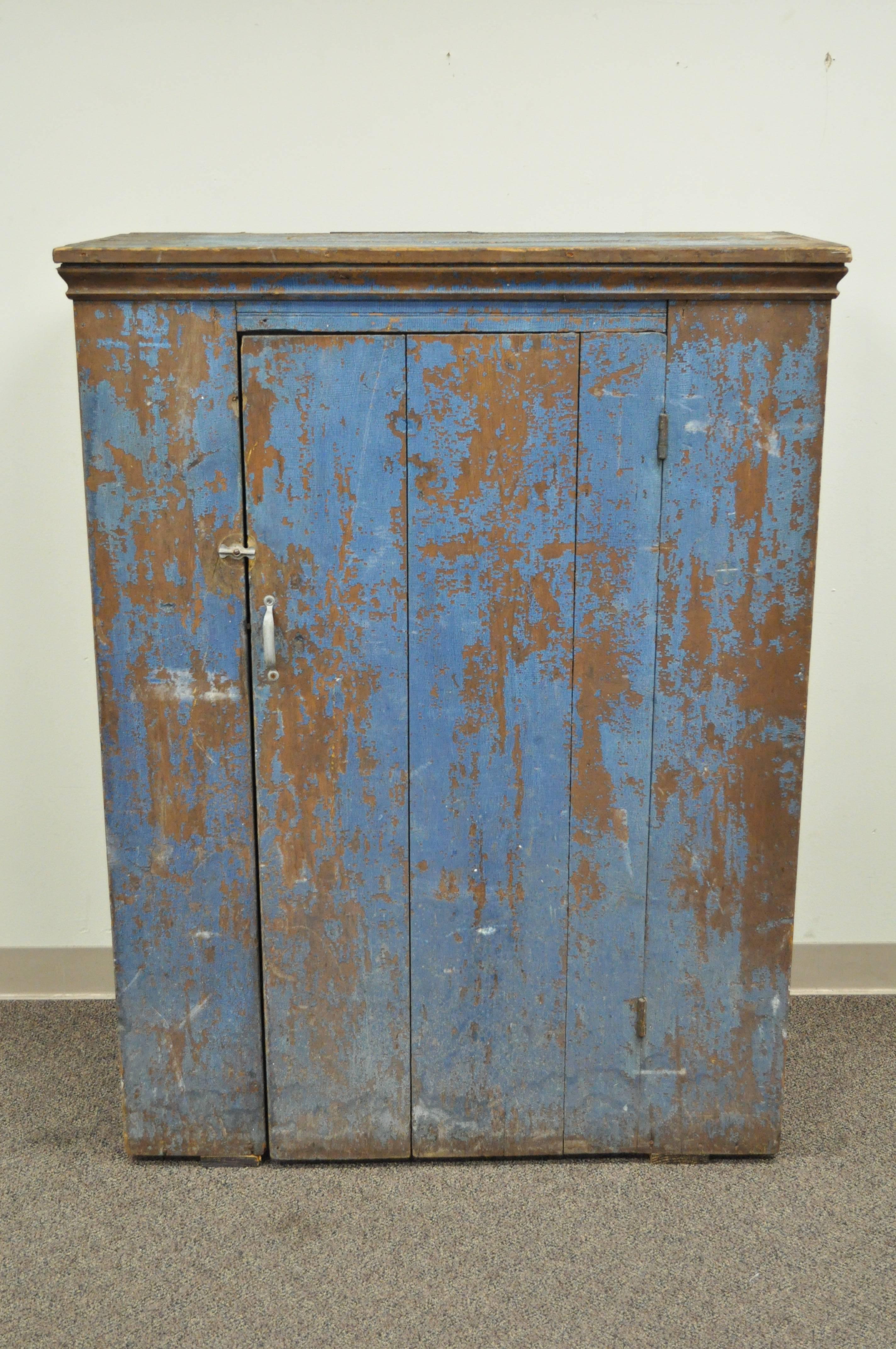 Charming early 19th century weathered and distressed handmade jelly cupboard with original blue painted finish from Pennsylvania Dutch Country. Item features solid wood construction, single swing door, three interior shelves, and desirable and