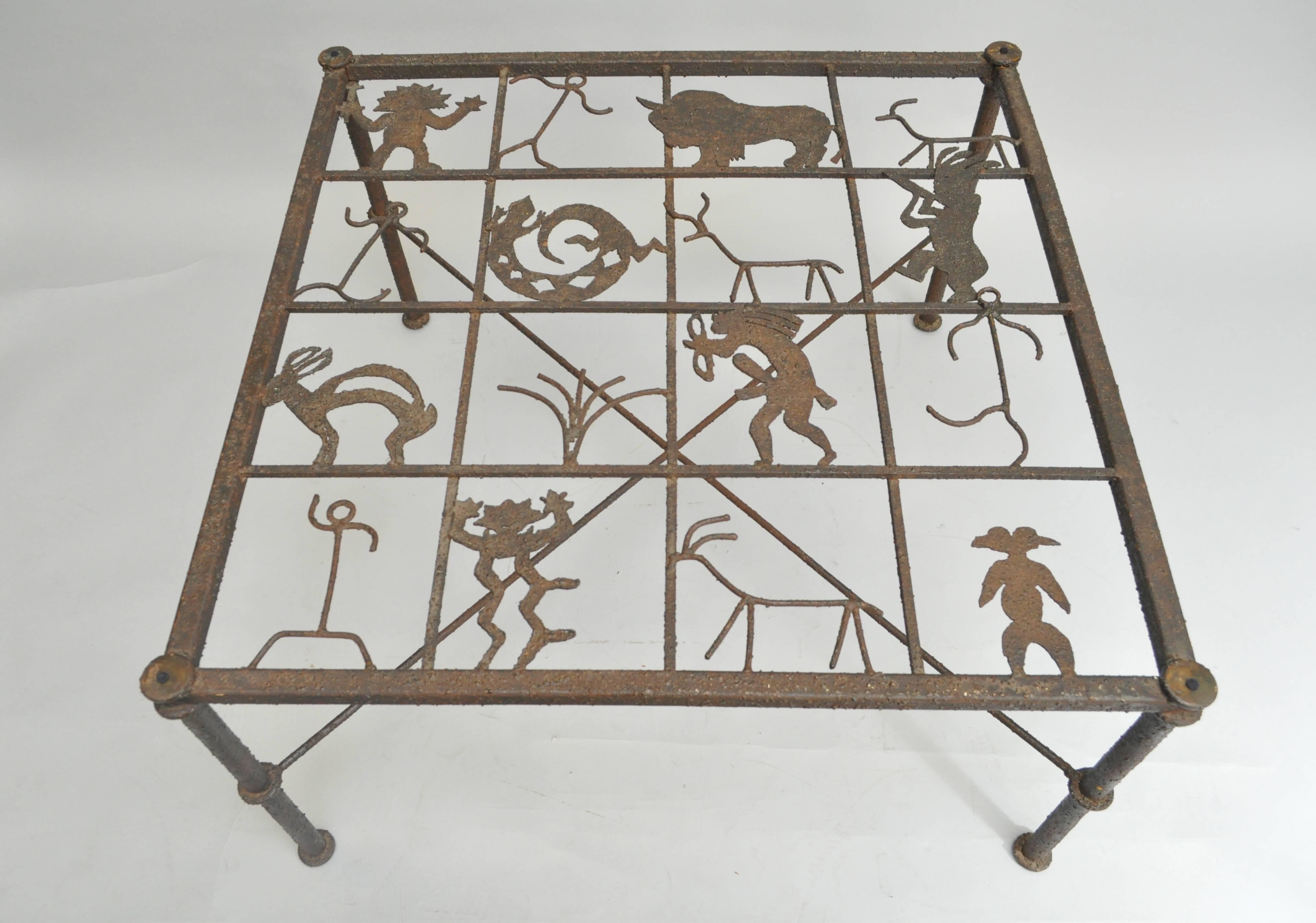 Very unique Brutalist style metal and glass square Brutalist coffee table with Welded Native American Style handmade Glyph Figures. Item features a patinated rustic metal frame with X-form stretcher base and 16 figures on the top which is covered by