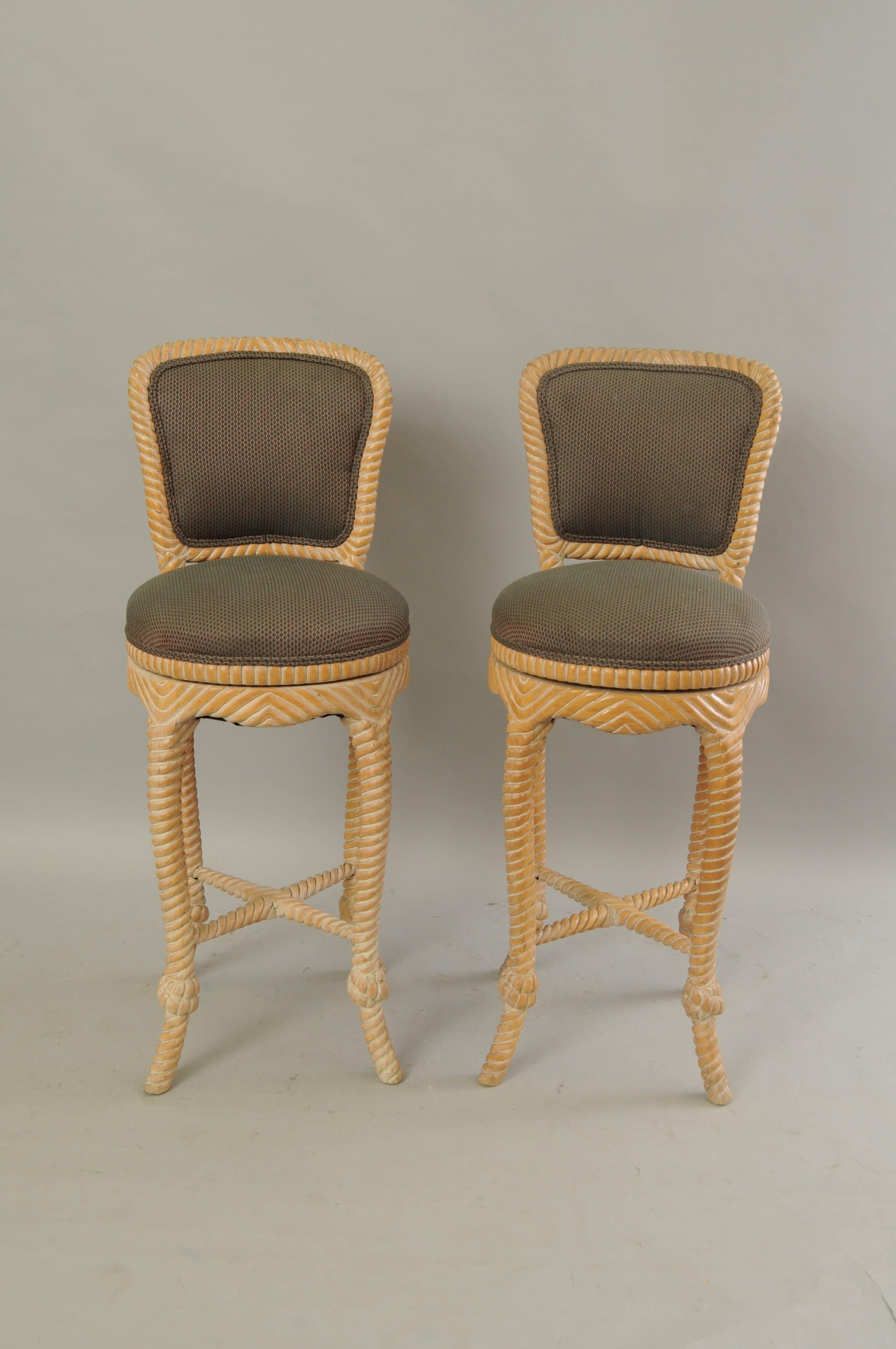 Pair of vintage Italian Hollywood Regency carved wood rope and tassel swivel barstools. Item features solid carved wood frames, upholstered backs, swivel seats, rope and knot carved design, great Italian Hollywood Regency form. Great for Mid-Century
